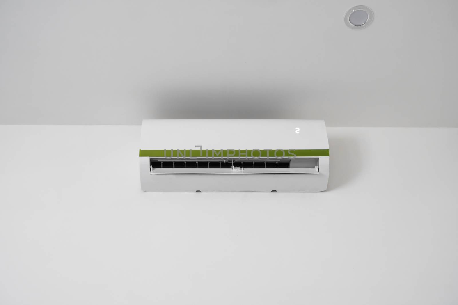 Air conditioner mounted on a white wall in the living room or bedroom. Indooor comfort temperature. Health concepts and energy savings. by vovsht