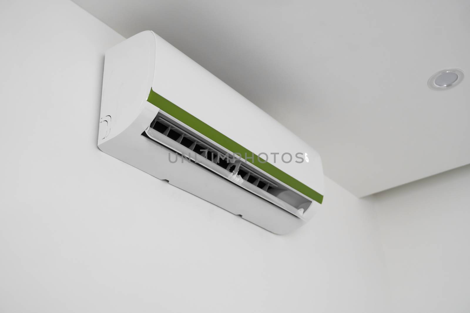 Air conditioner mounted on a white wall in the living room or bedroom. Indooor comfort temperature. Health concepts and energy savings. by vovsht