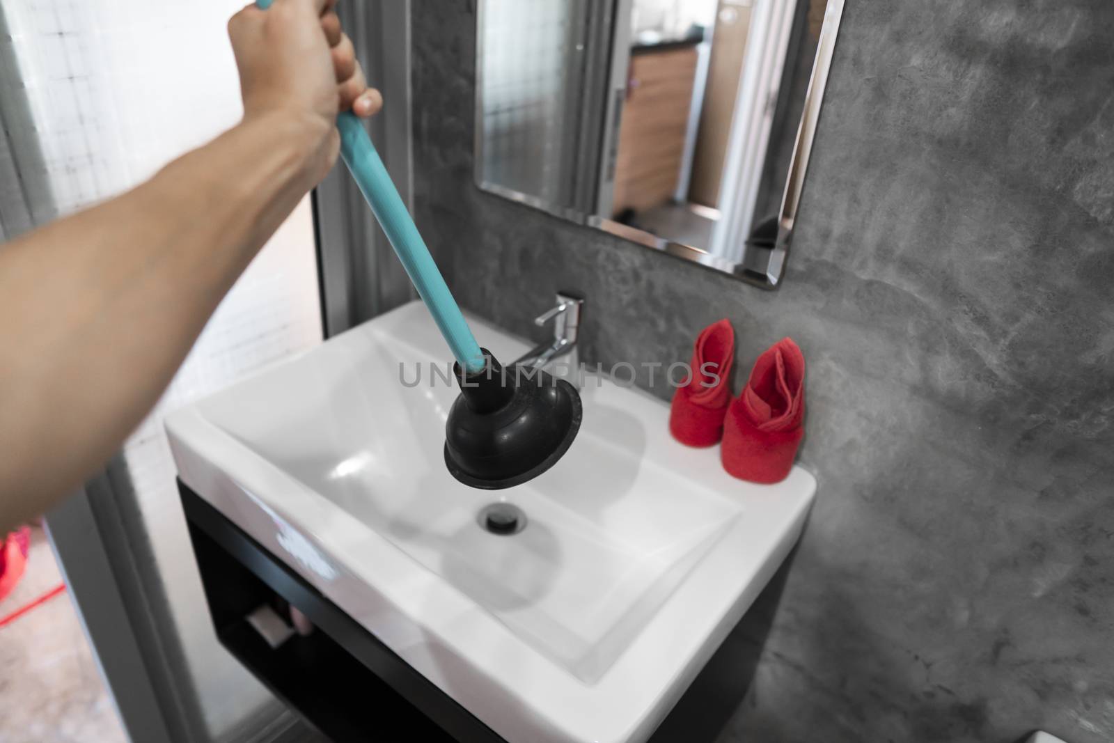 Toilet repair by hand with a Toilet Plunger. Plumbing. A plumber uses a plunger to unclog a toilet. Toilet Plunger