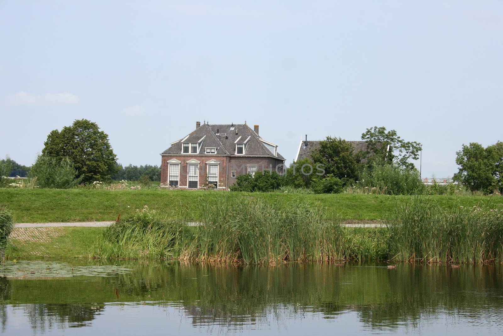 Lonely old House, with a body of water in the foreground 