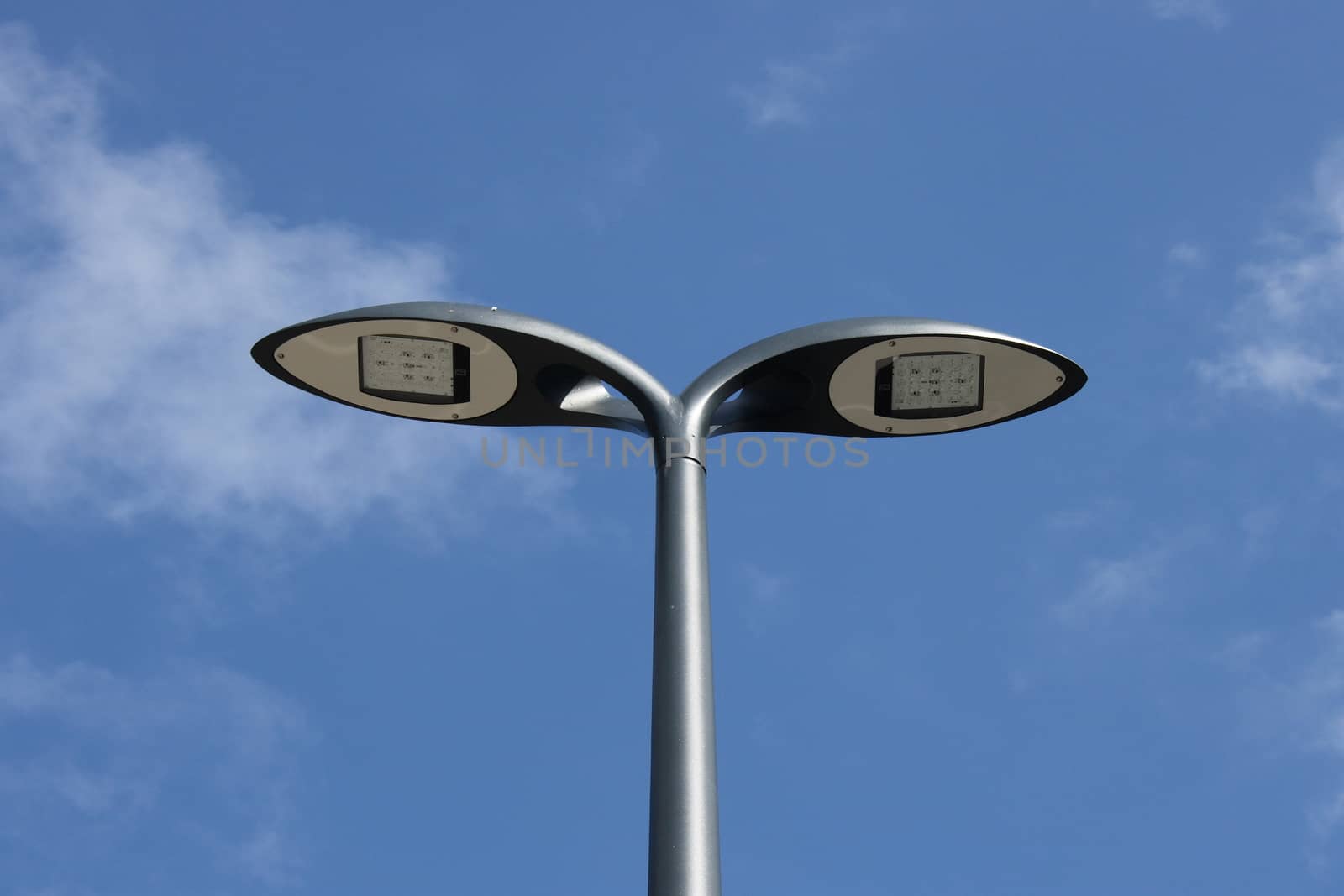 Street light with two lamps, blue sky in the background 