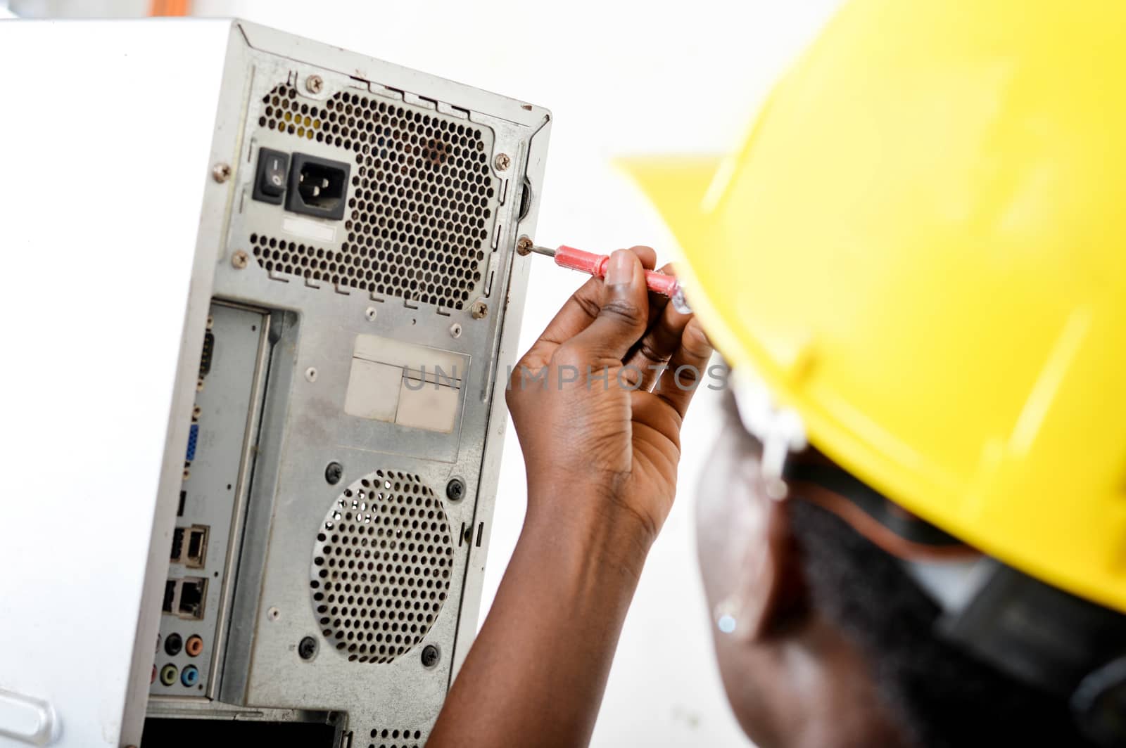 Close-up of a worker's head opening a computer with a vice turn.