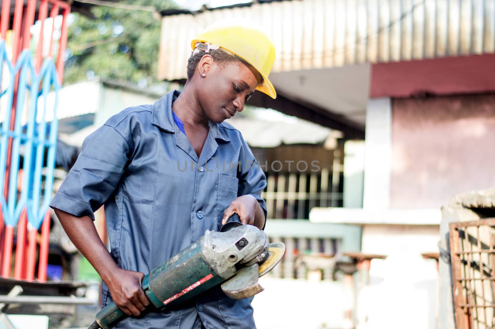 Young woman holding her working tool and ready to polish a welded iron.