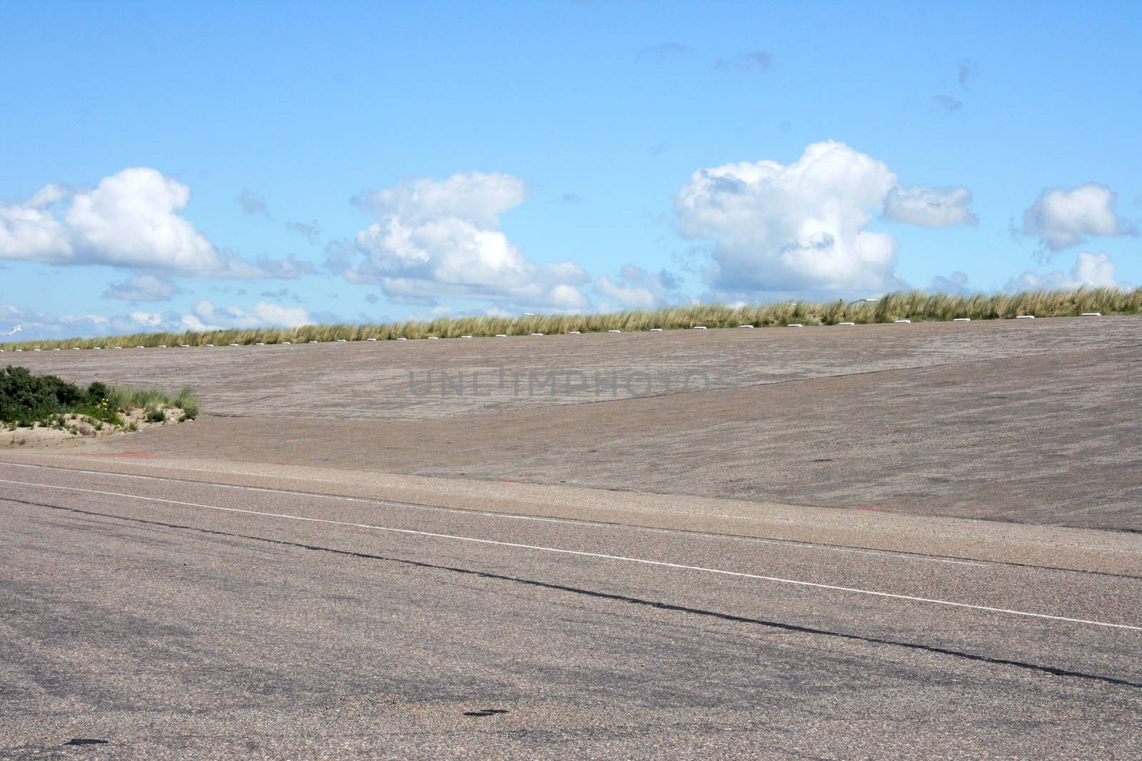 Dam at the Dutch North Sea coast, with blue sky in background