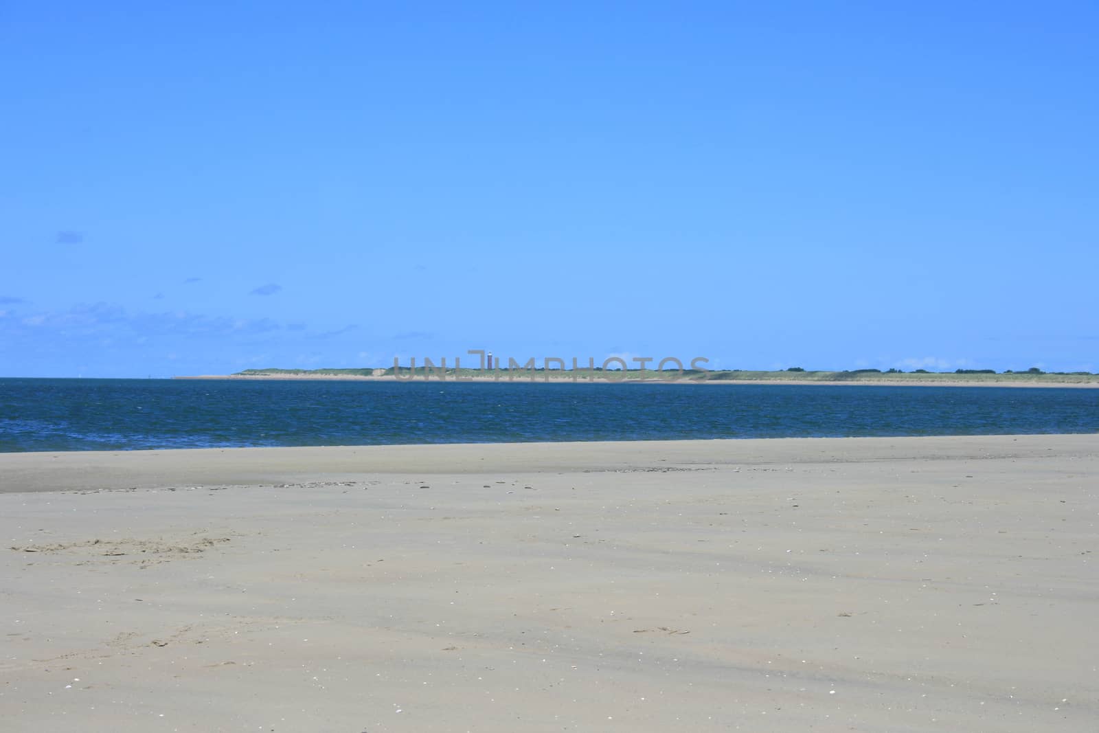 Sandy beach with sea and blue sky background