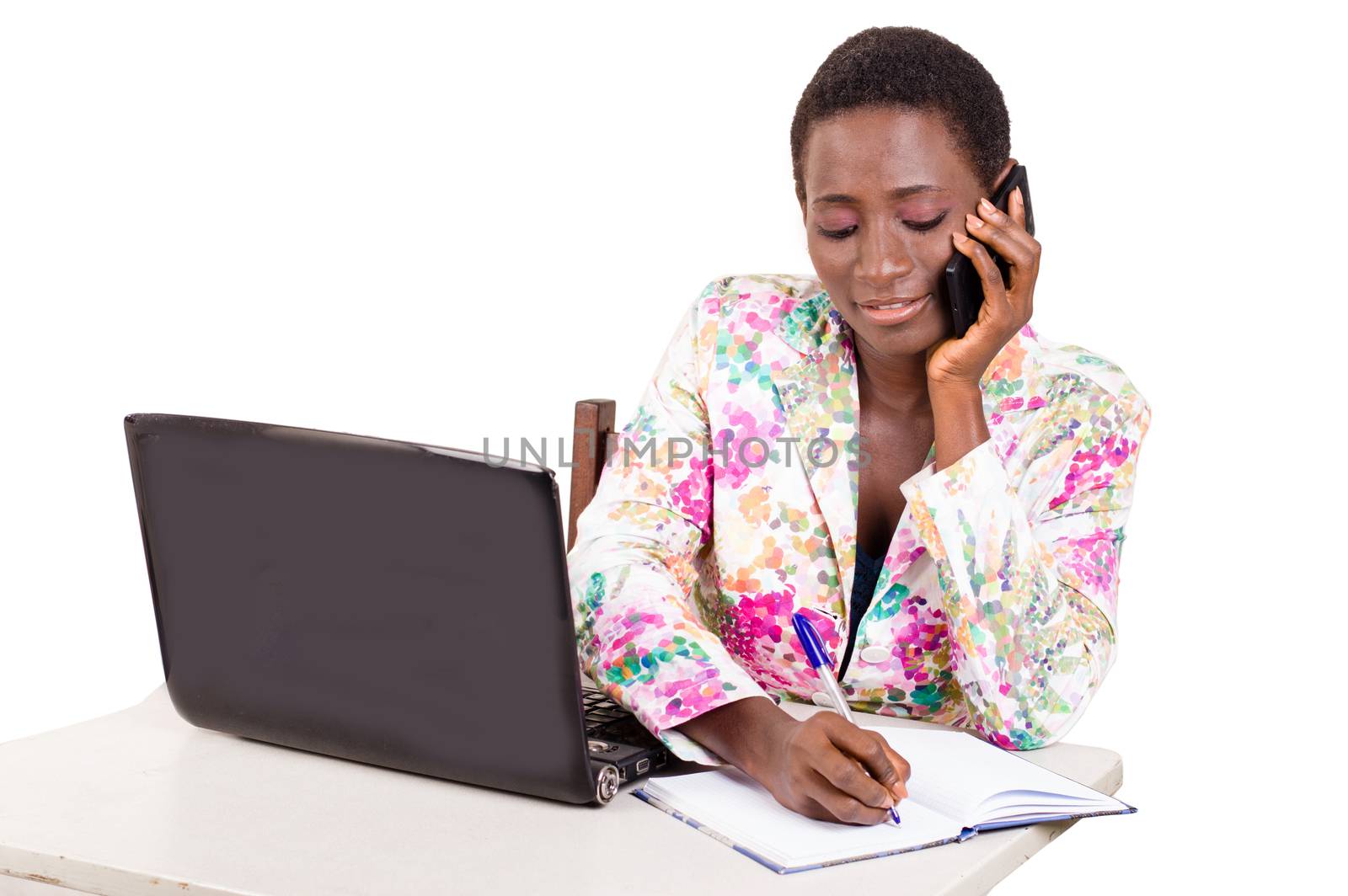 Young happy business woman working on a laptop by calling on mobile phone