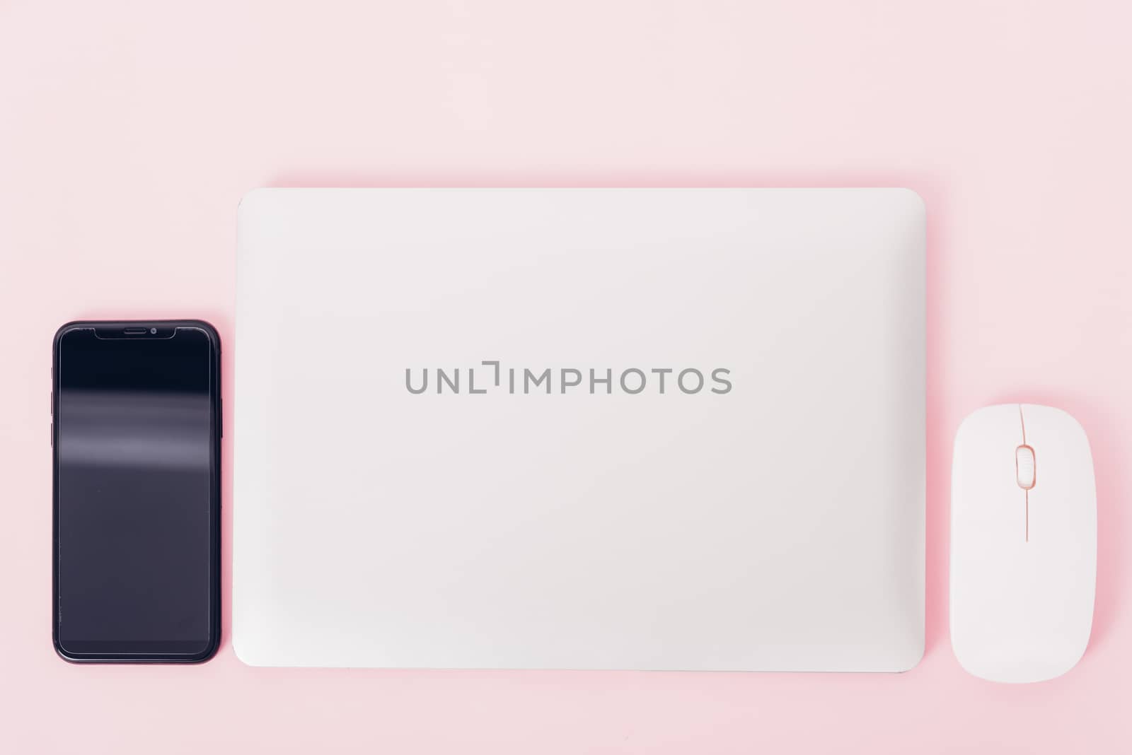 Top view of modern technology smart phone mobile and computer laptop close cover on pink background with copy space