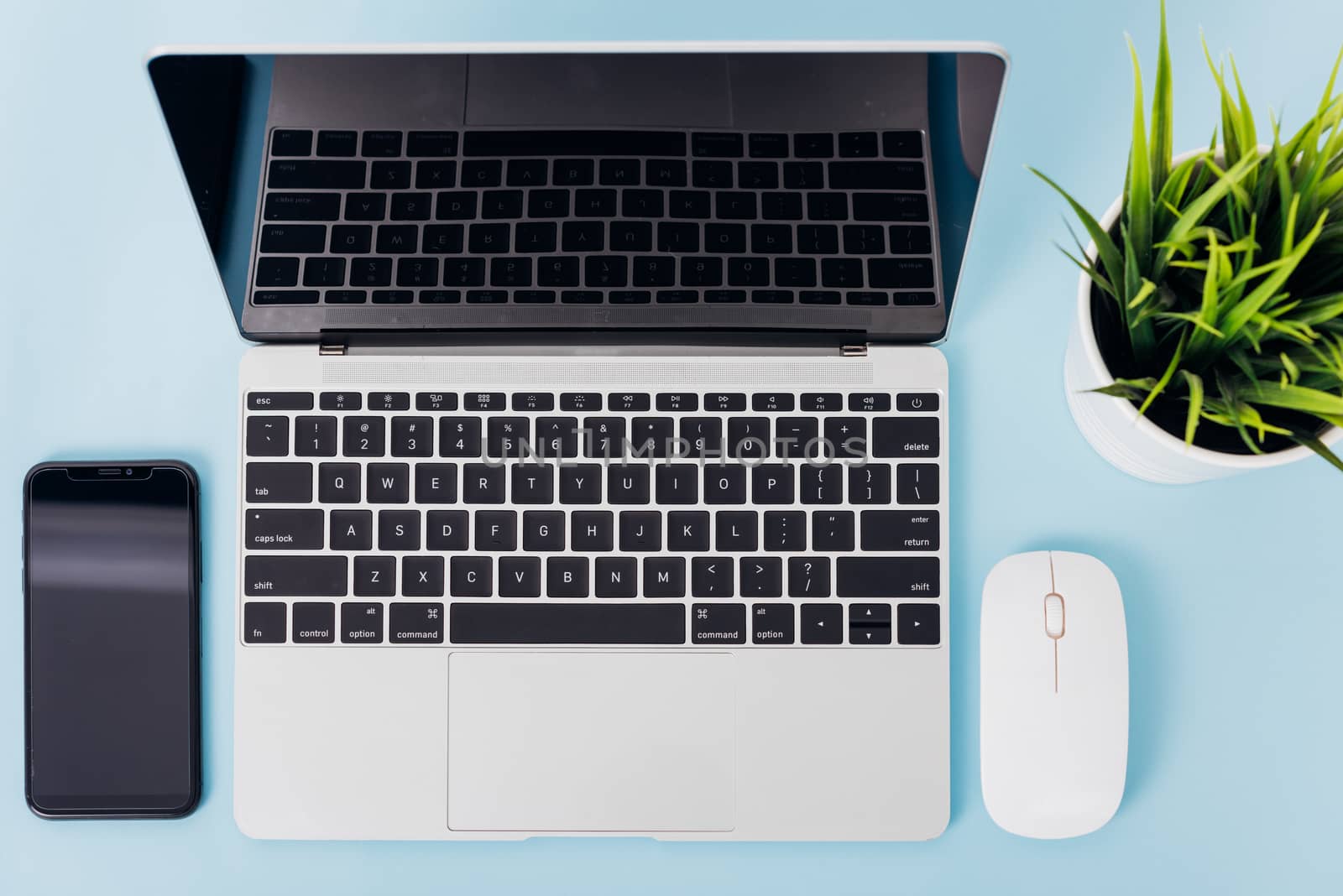 Top view of modern technology smart phone mobile and computer laptop on blue background with copy space