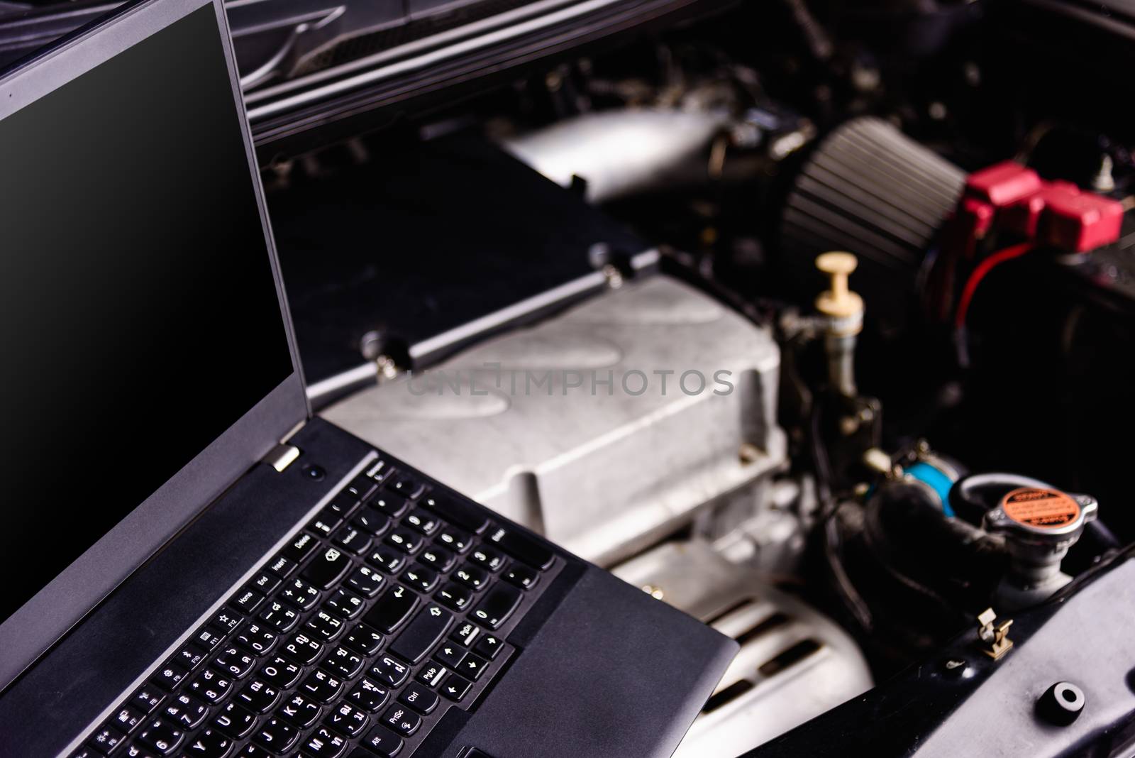 Laptop computer on car mechanic engine for service at workshop