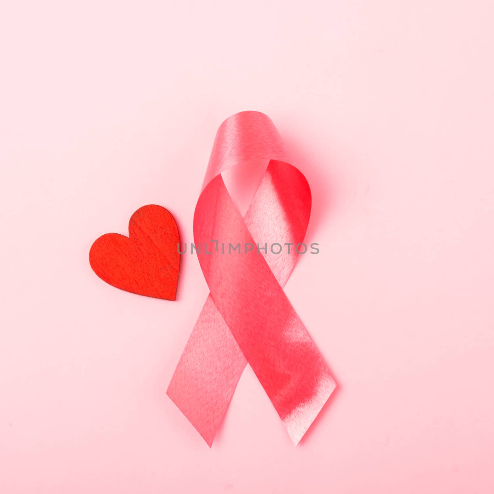 Breast cancer month health concept, flat lay top view, put pink ribbon and Red Heart on pink background with copy space for your text