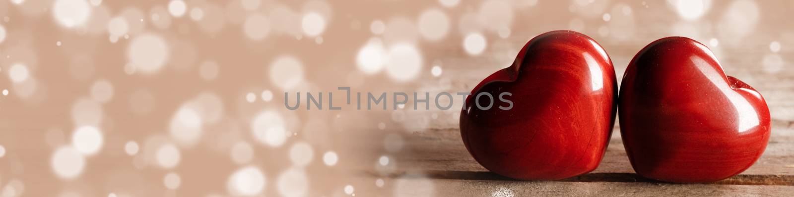Two red wooden hearts symbol of love on wooden background and bokeh lights, Saint Valentine Day celebration, copy space for text