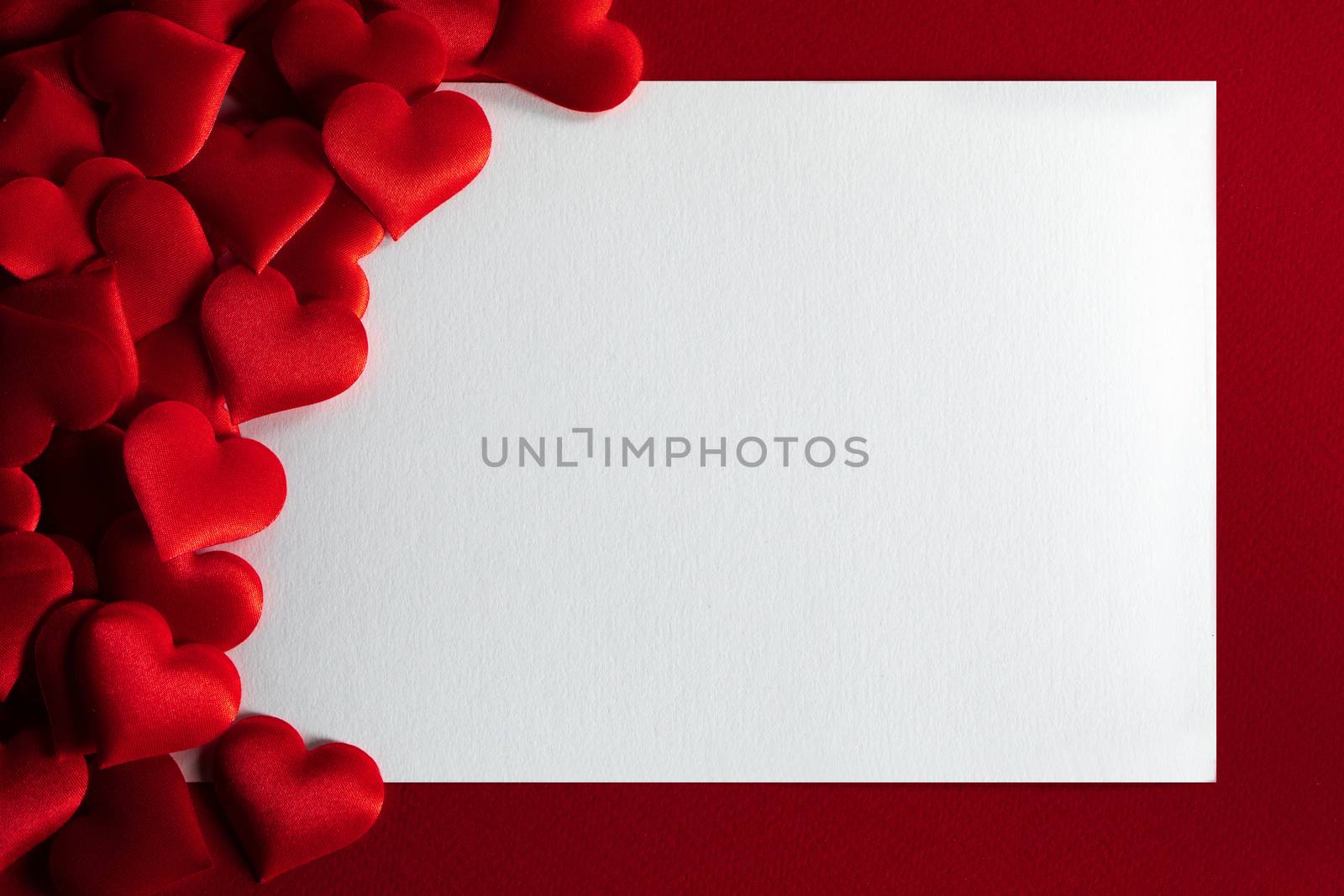 Valentine's day many red silk hearts background , border frame with white card with copy space, love concept