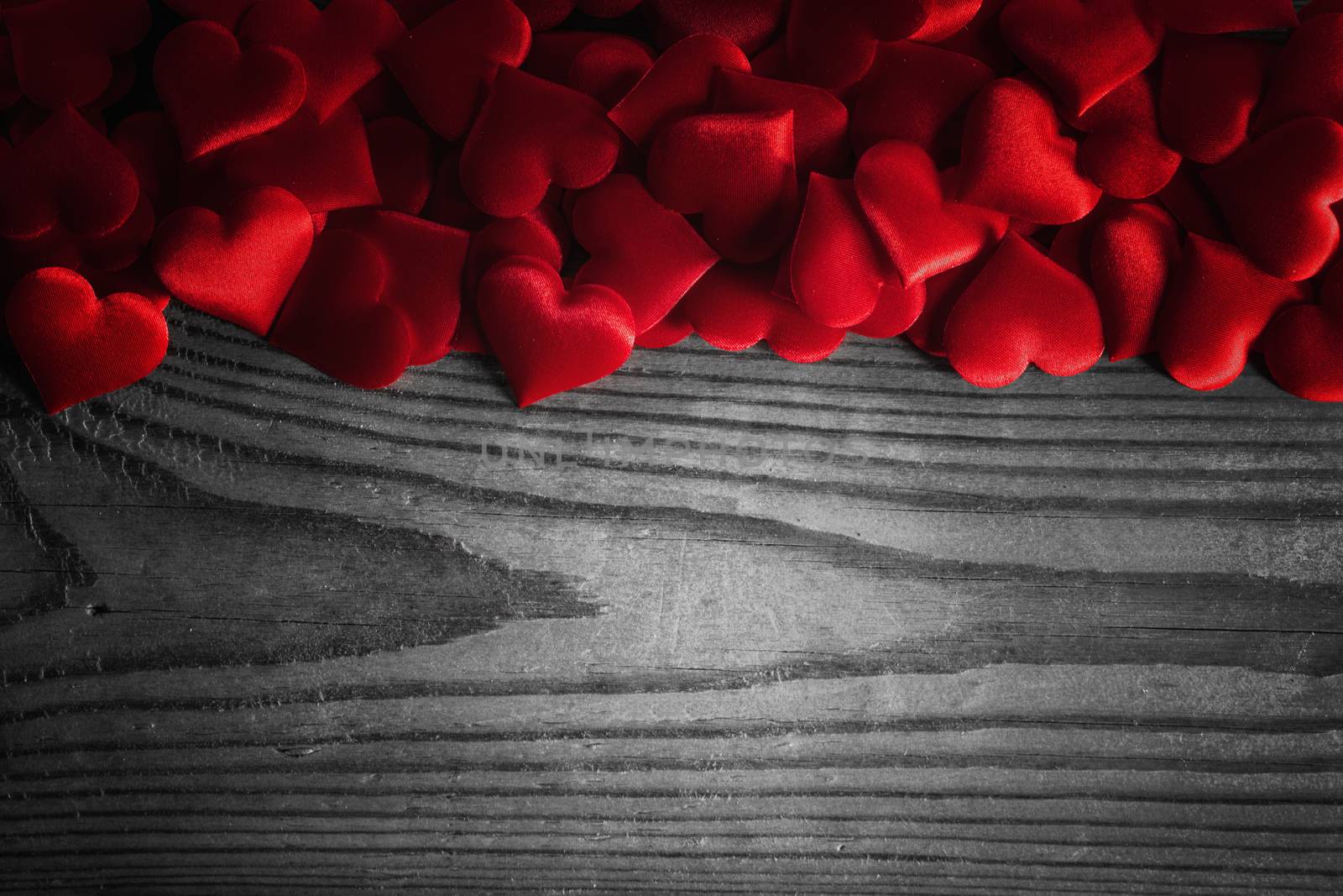 Valentine's day many red silk hearts on wooden background, love concept