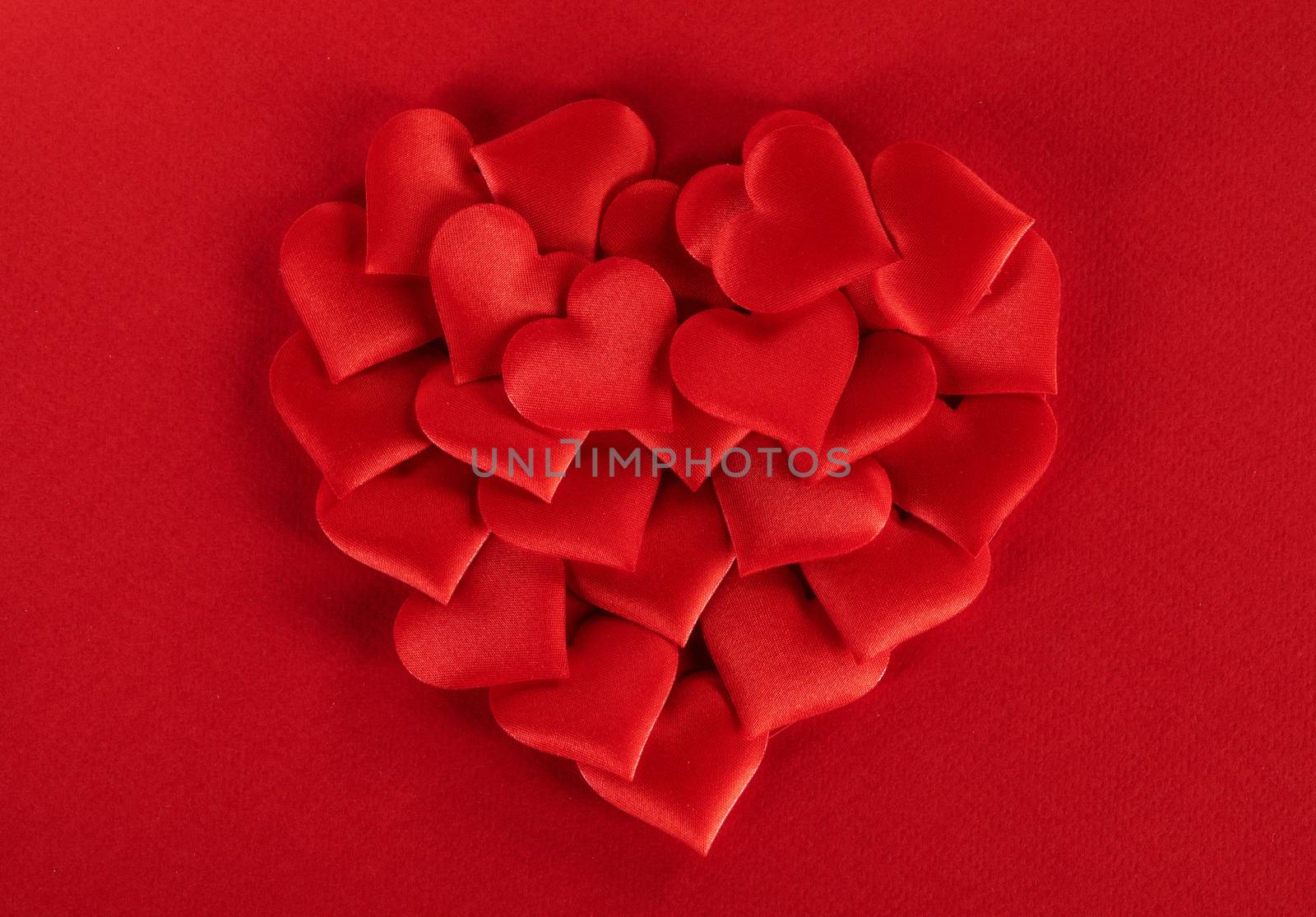 Valentine's day many red silk hearts ob paper background, love concept