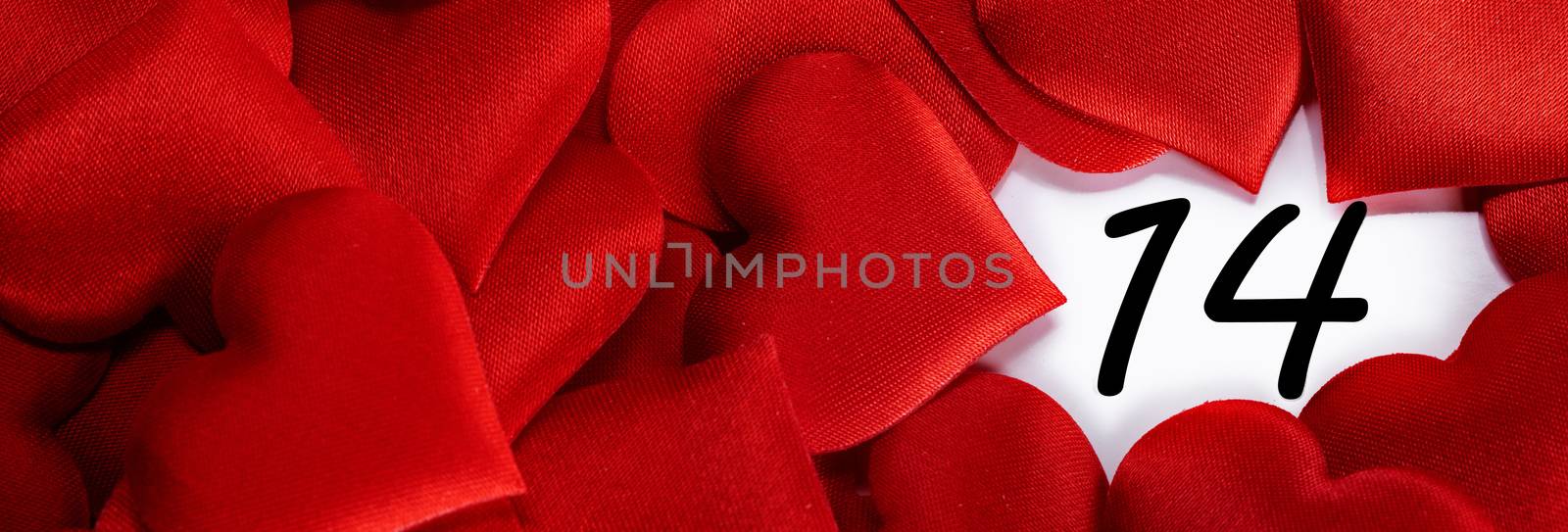 Valentine's day red silk hearts on calendar with 14 february date background, love, celebration concept