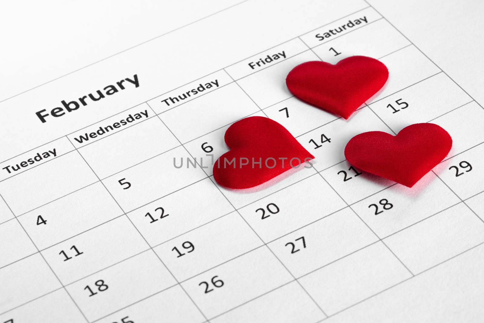 Valentine's day red silk hearts on calendar with 14 february date background, love, celebration concept