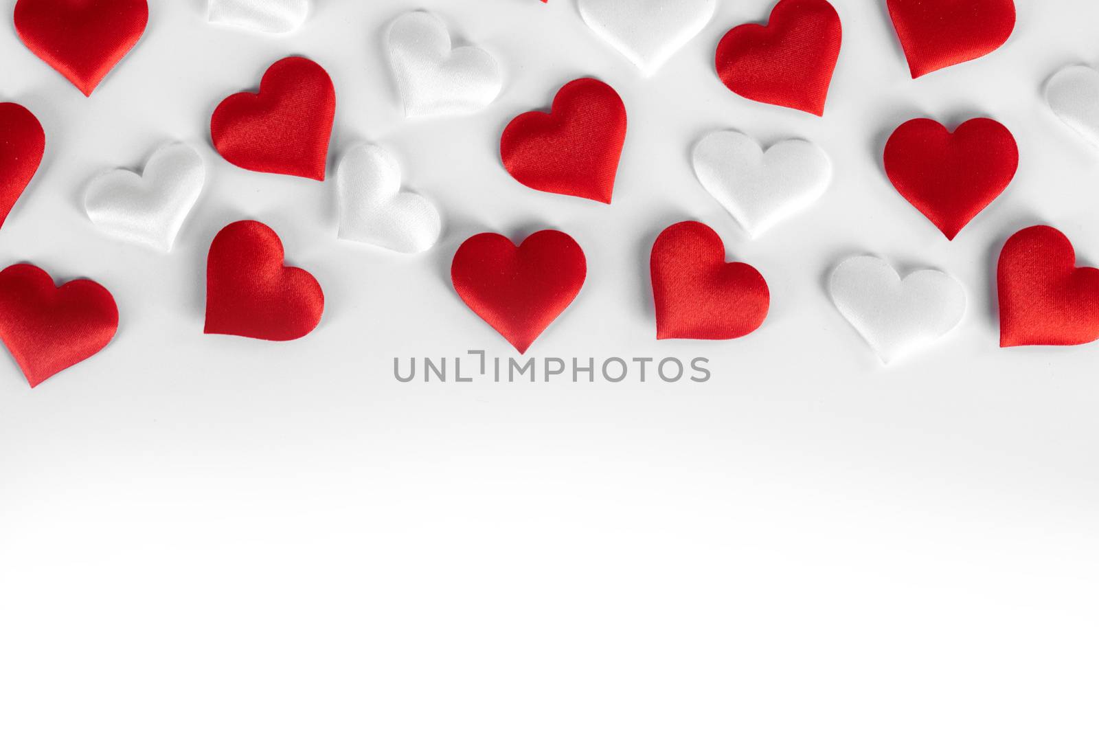 Valentine's day many red and white silk hearts on white background , border frame with copy space, love concept