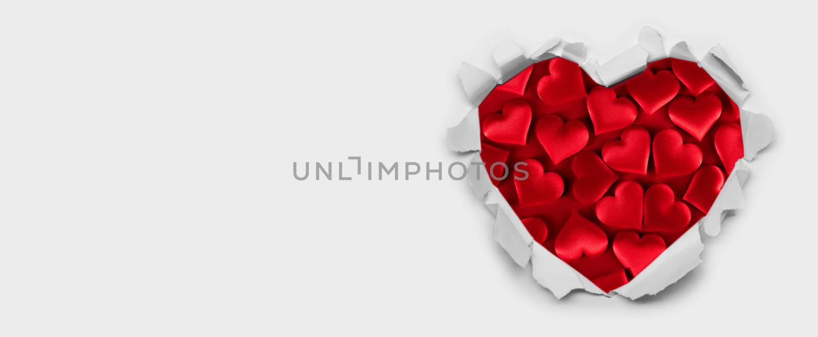 Torn white paper heart over red hearts background with copy space for text, Valentine's day love concept