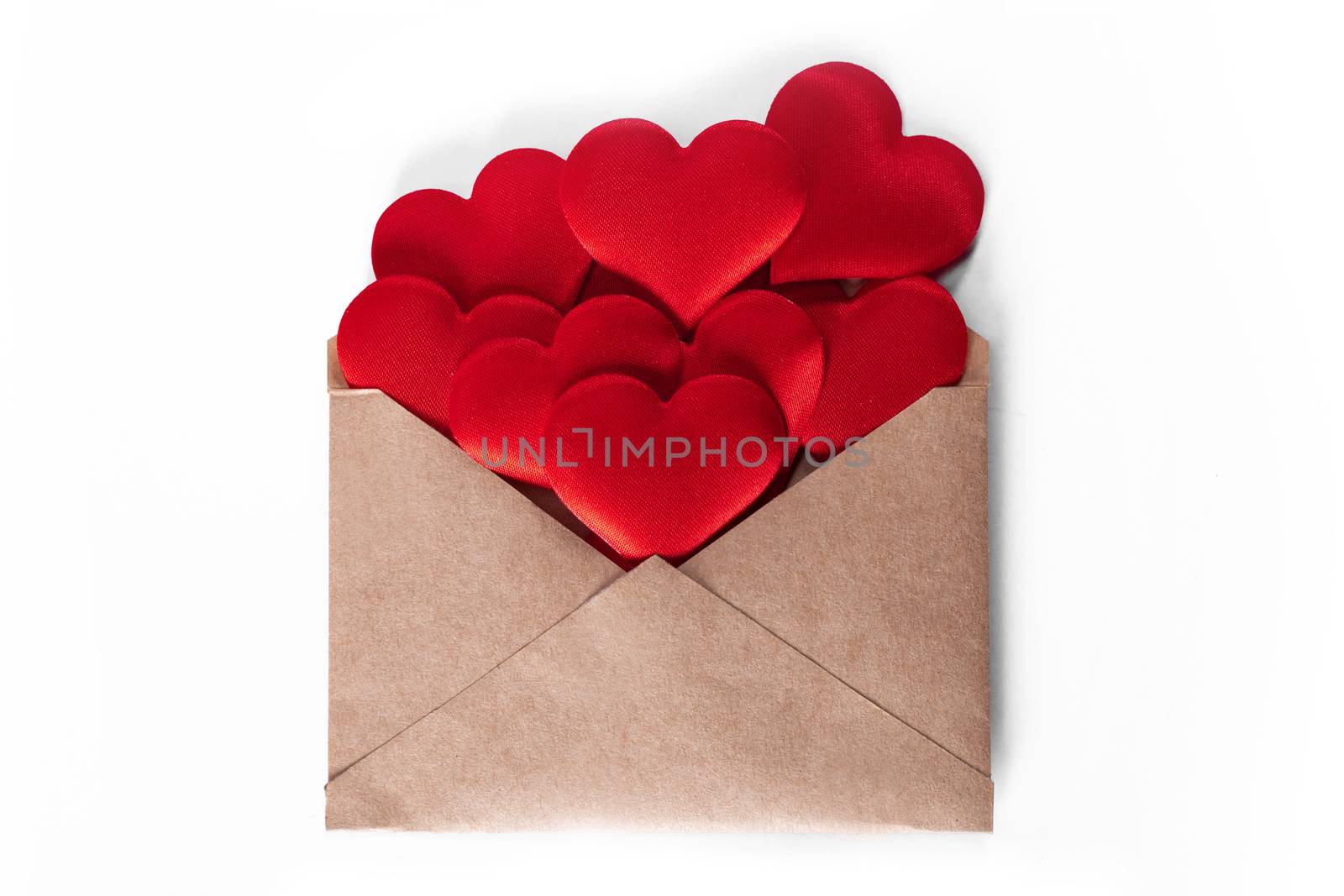 Valentine day love letter, envelope of craft paper with red hearts heap spread on white background.