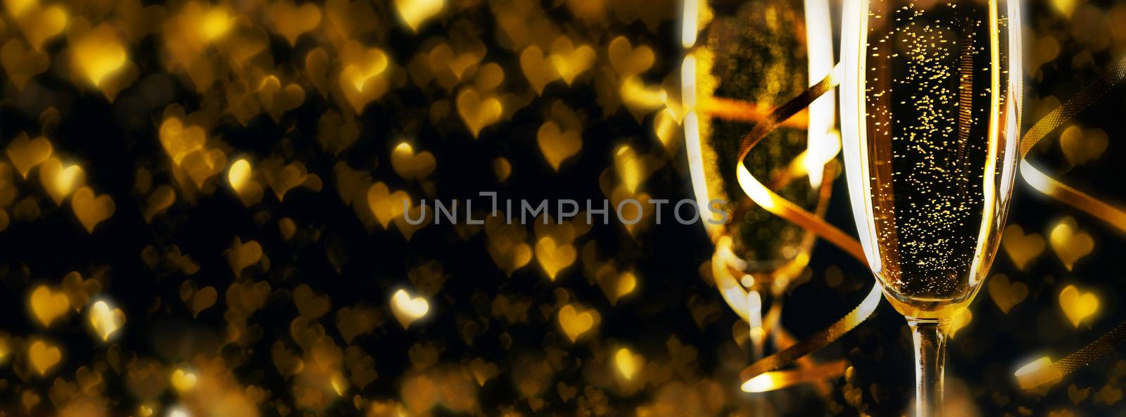 Two glasses of champagne ribbons and heart shaped bokeh lights on black background, Romance, evening, dating, Valentines day concept