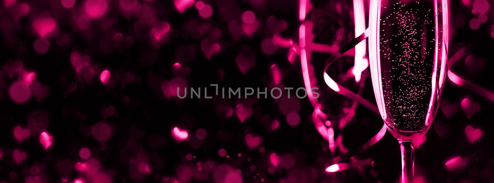 Two glasses of champagne ribbons and heart shaped bokeh lights on black background, Romance, evening, dating, Valentines day concept