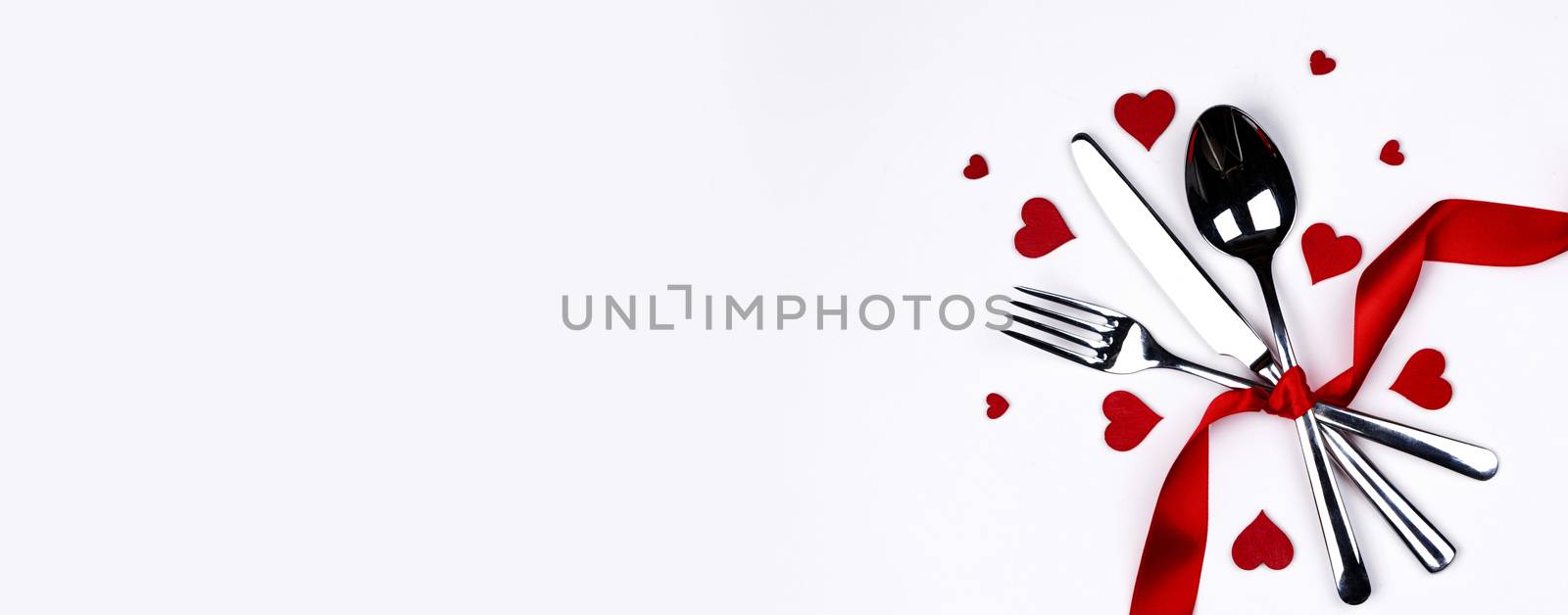 Cutlery set tied with silk ribbon and hearts isolated on white background Valentine day romantic dinner concept