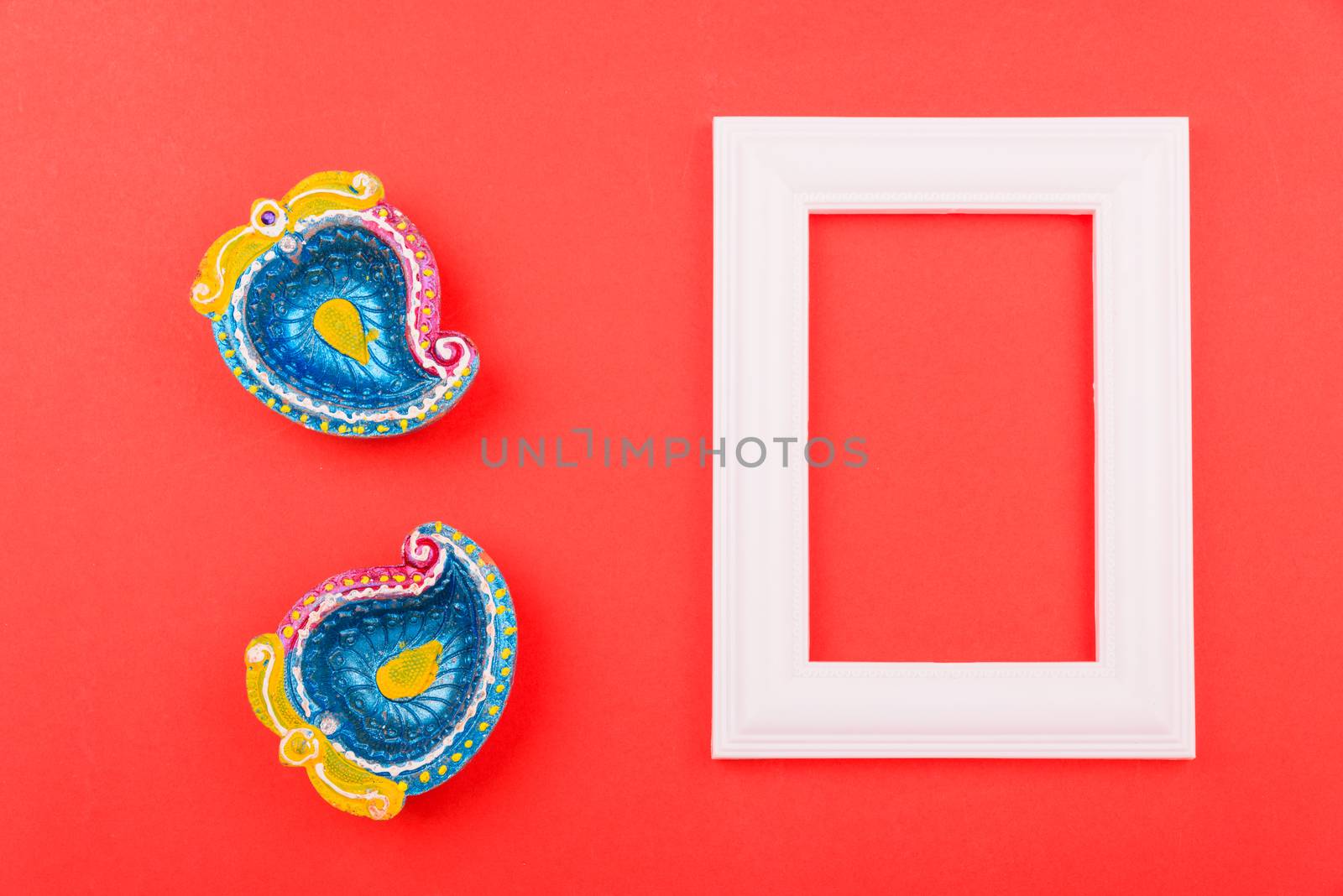 Happy Diwali Day, Flat lay top view Colorful Clay Diya lamps and photo frame on red background and copy space for your text