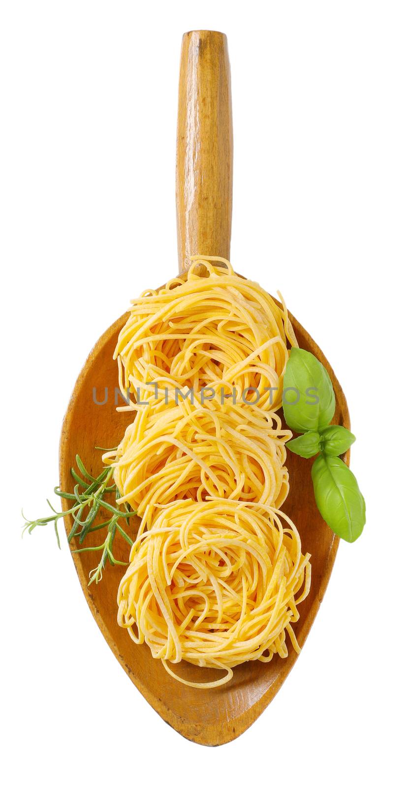 bundles of spaghetti pasta and herbs in wooden scoop