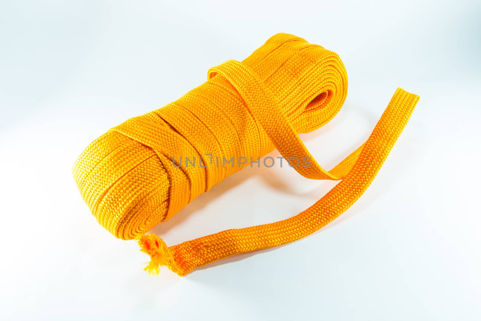 Orange rope rolls flat on white background.
