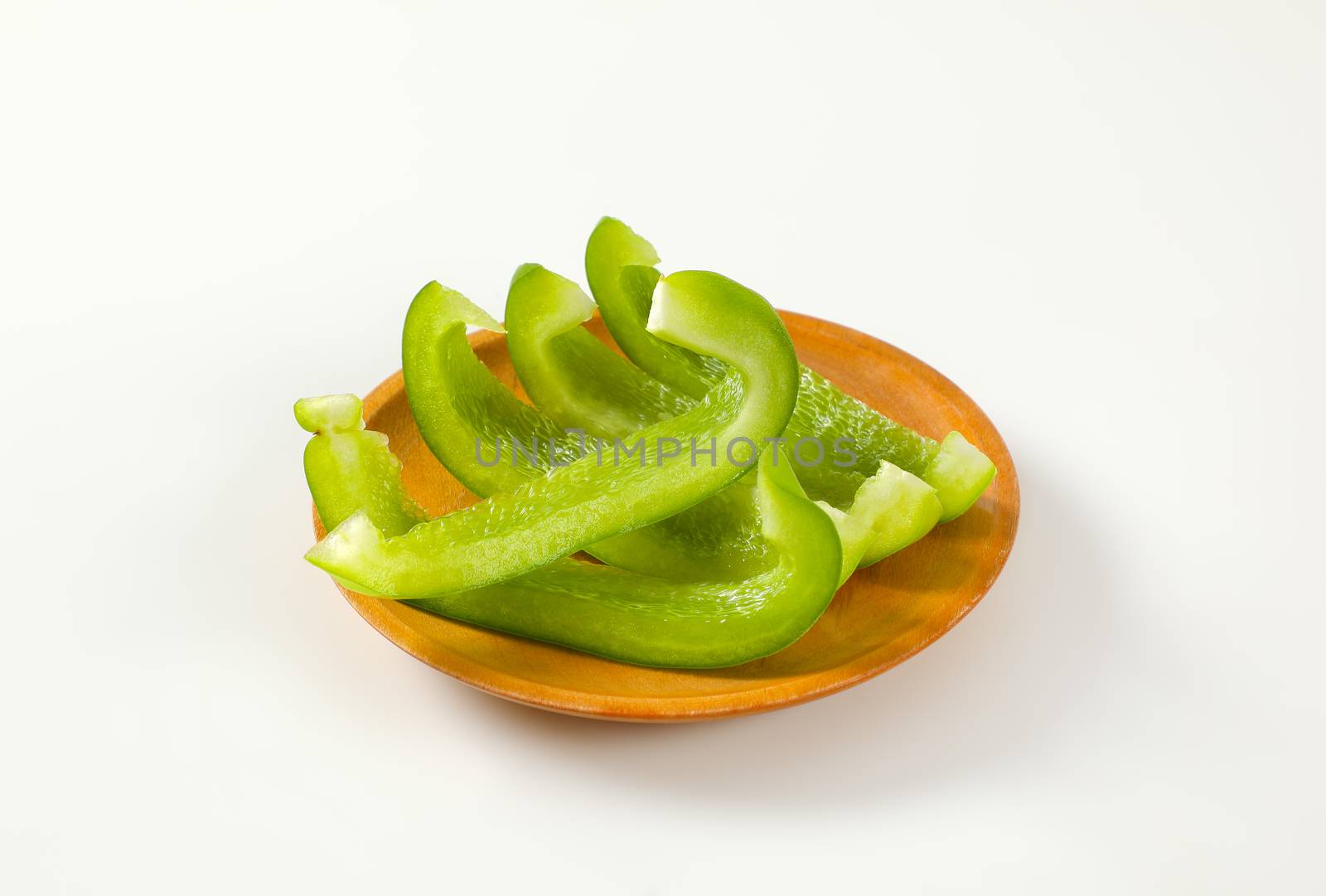 Slices of fresh green bell pepper on plate