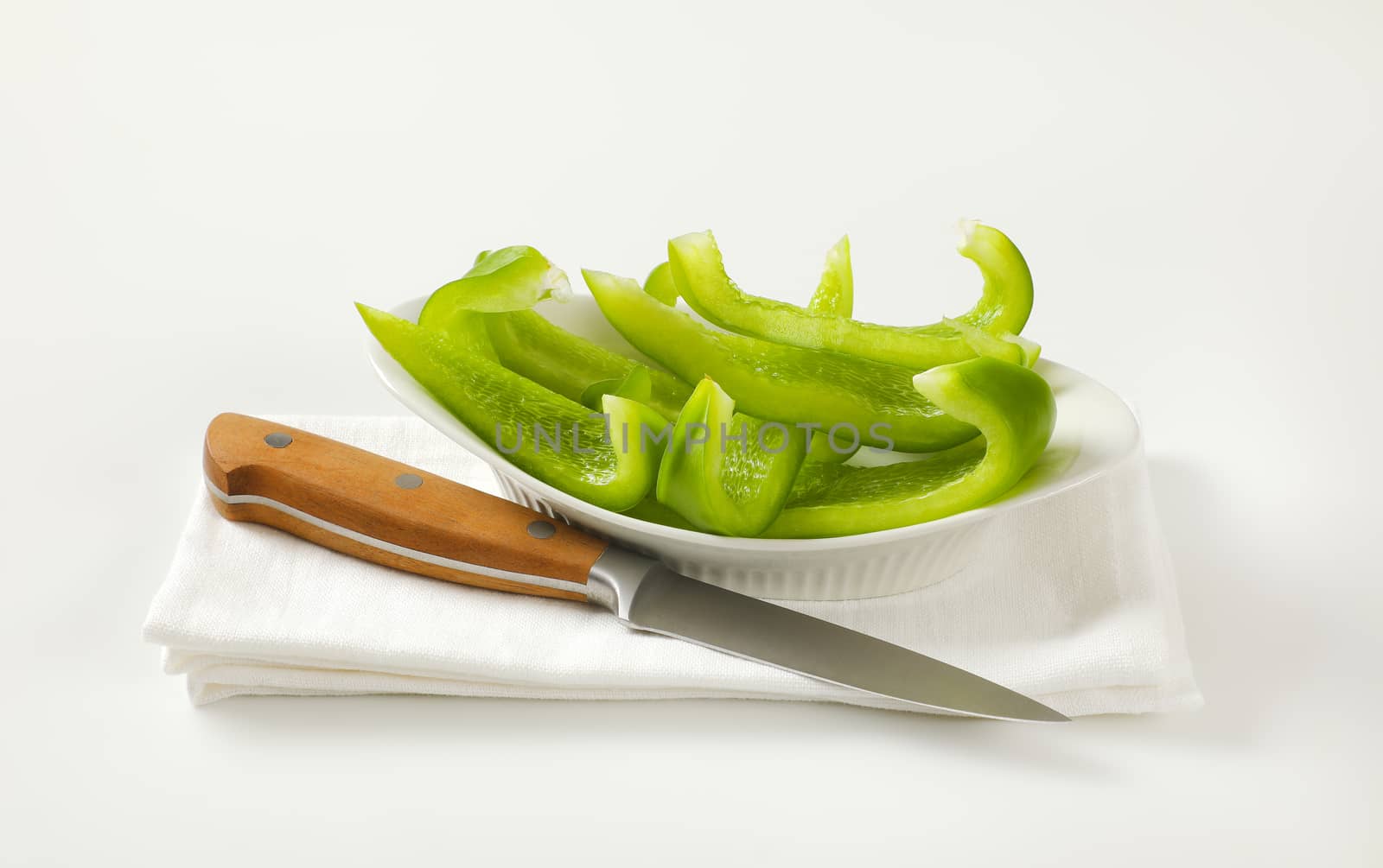 Green bell pepper slices in bowl by Digifoodstock