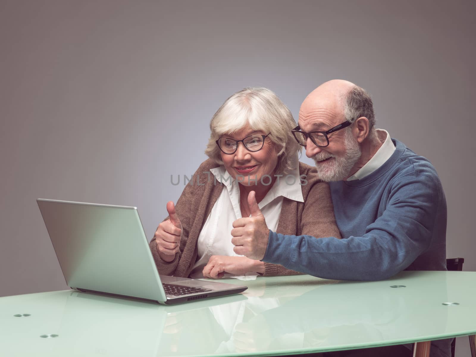 Senior couple using laptop together and smiling