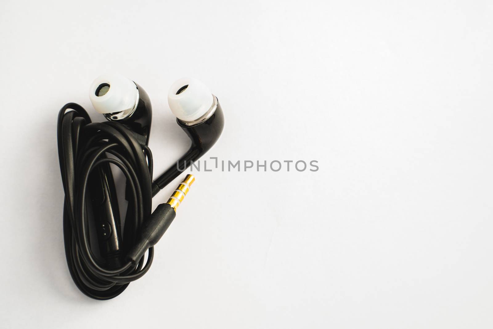 A Black earphones on a white background with space for put the text