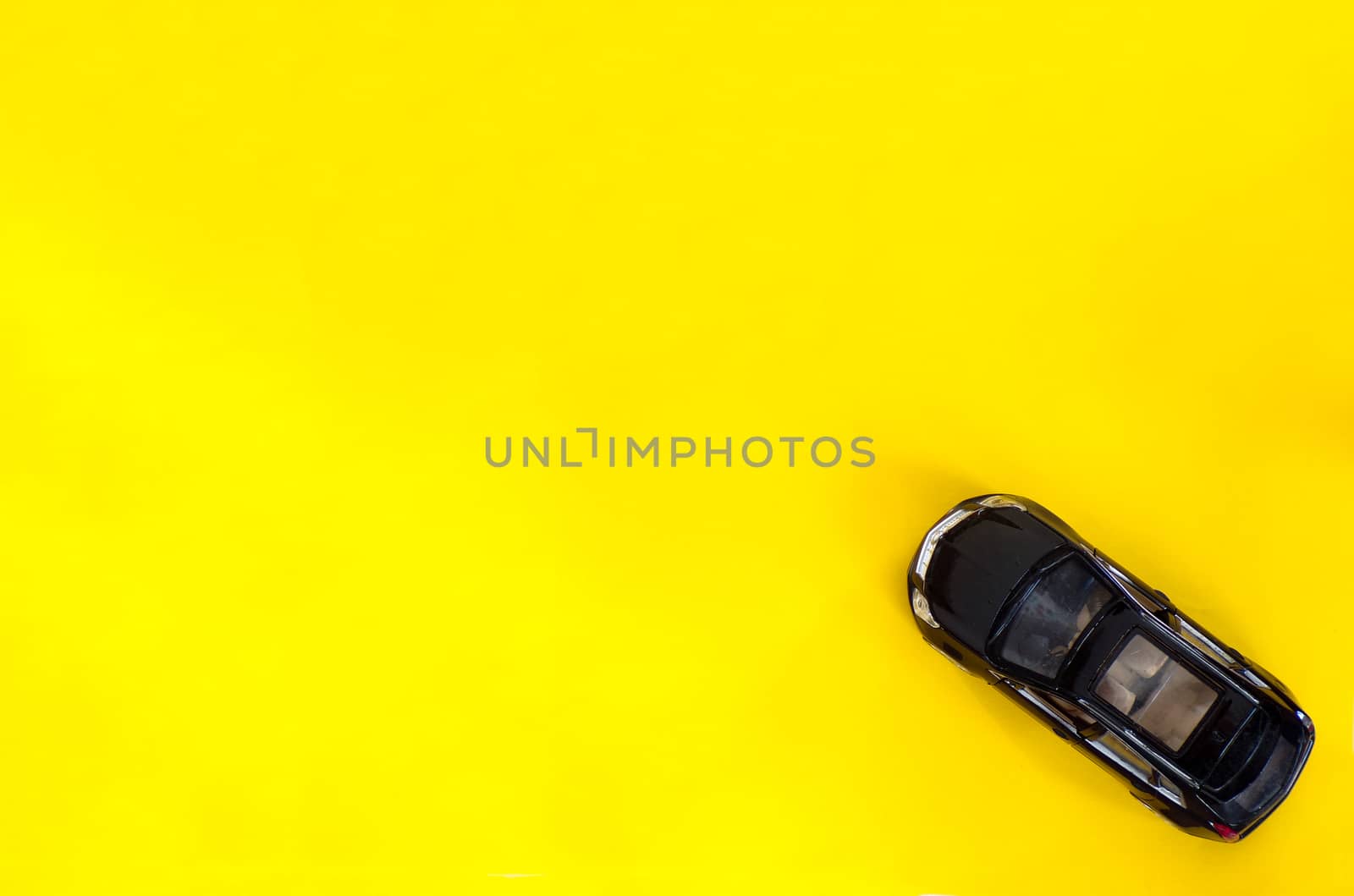 Car toy on a yellow background on top. Copy space.