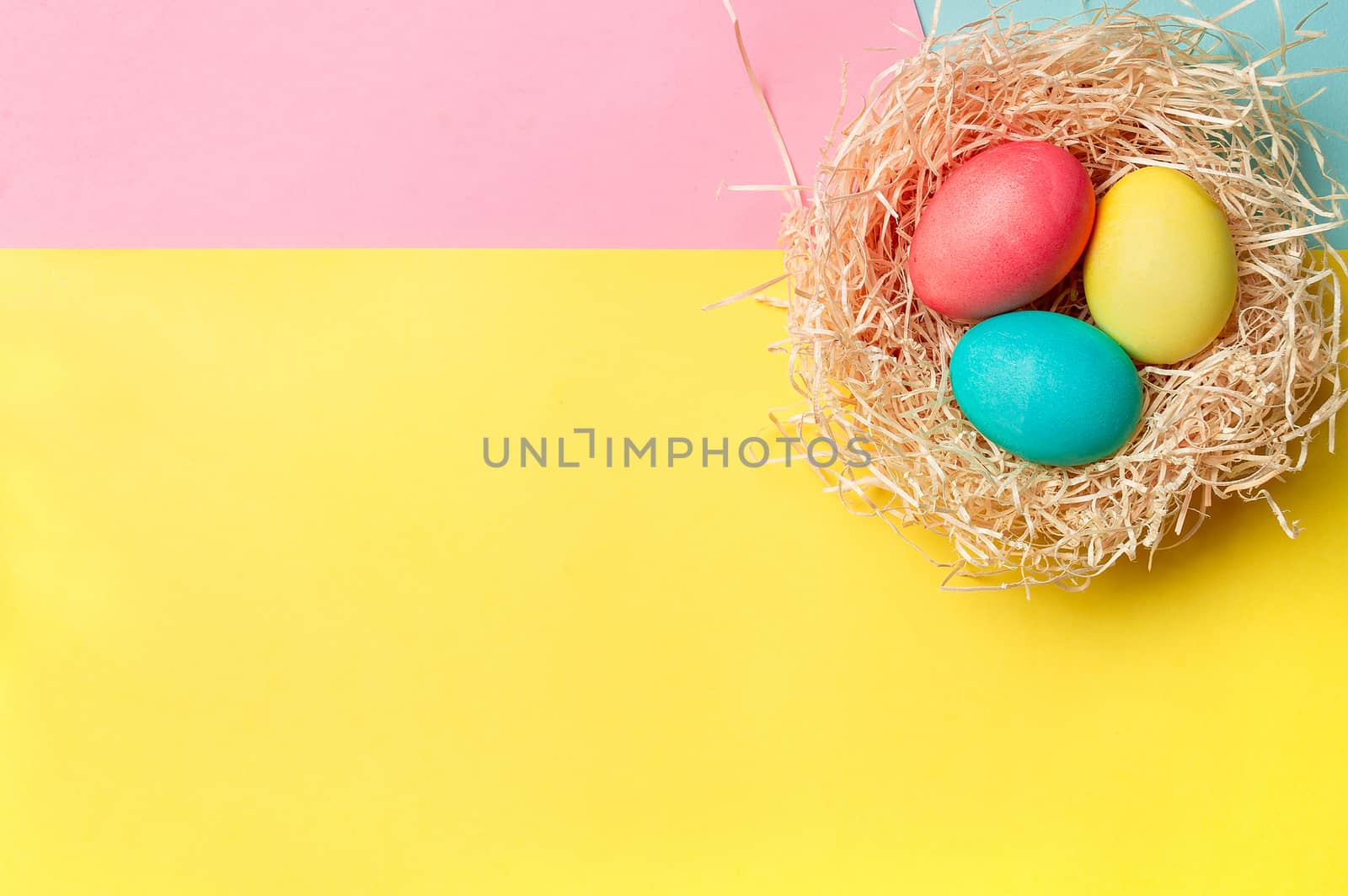 Easter concept. Colorful eggs on bright colorful background with copy space for text. Top down view or flat lay