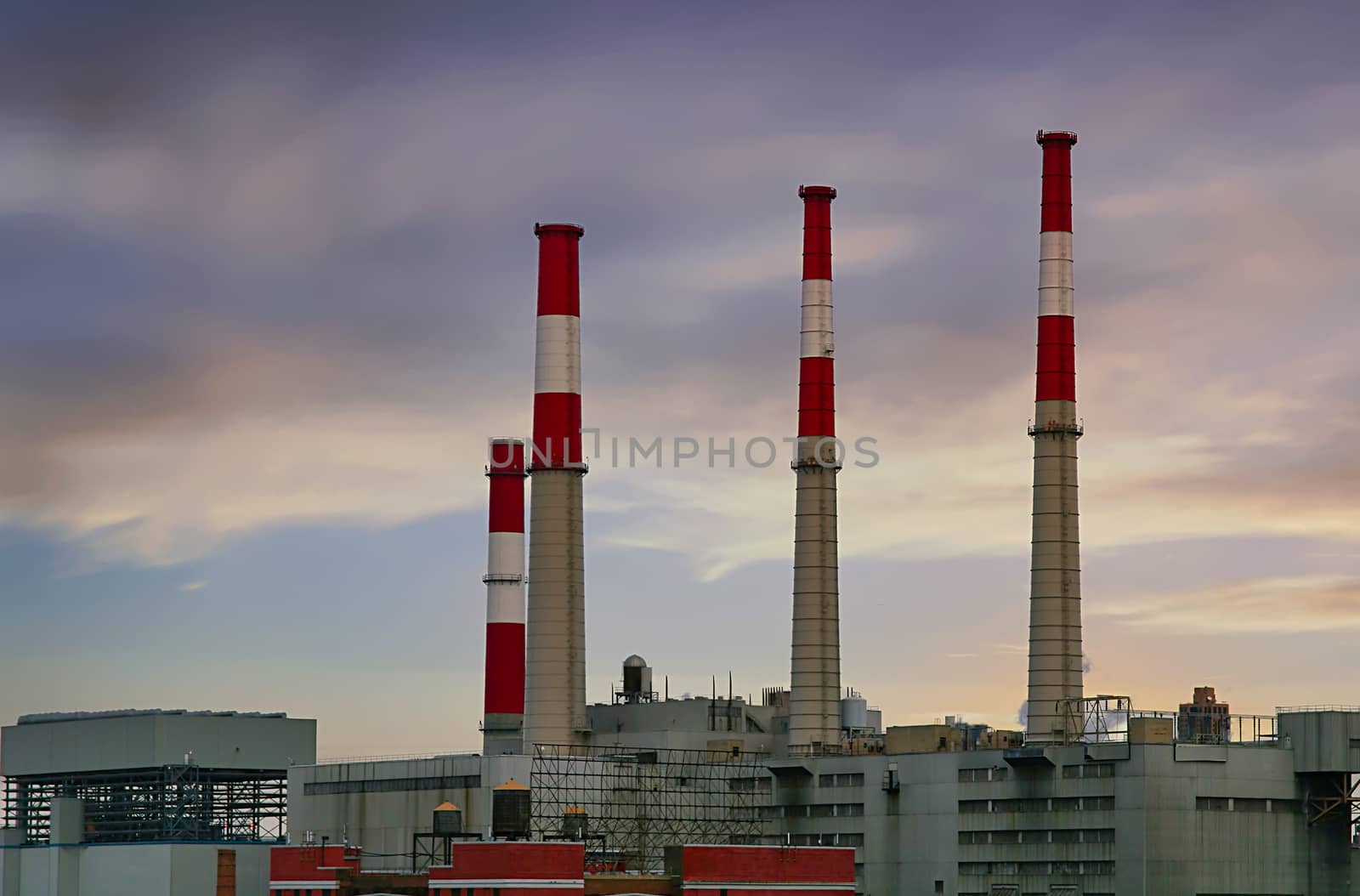 Red and white smokestacks in industrial part of city