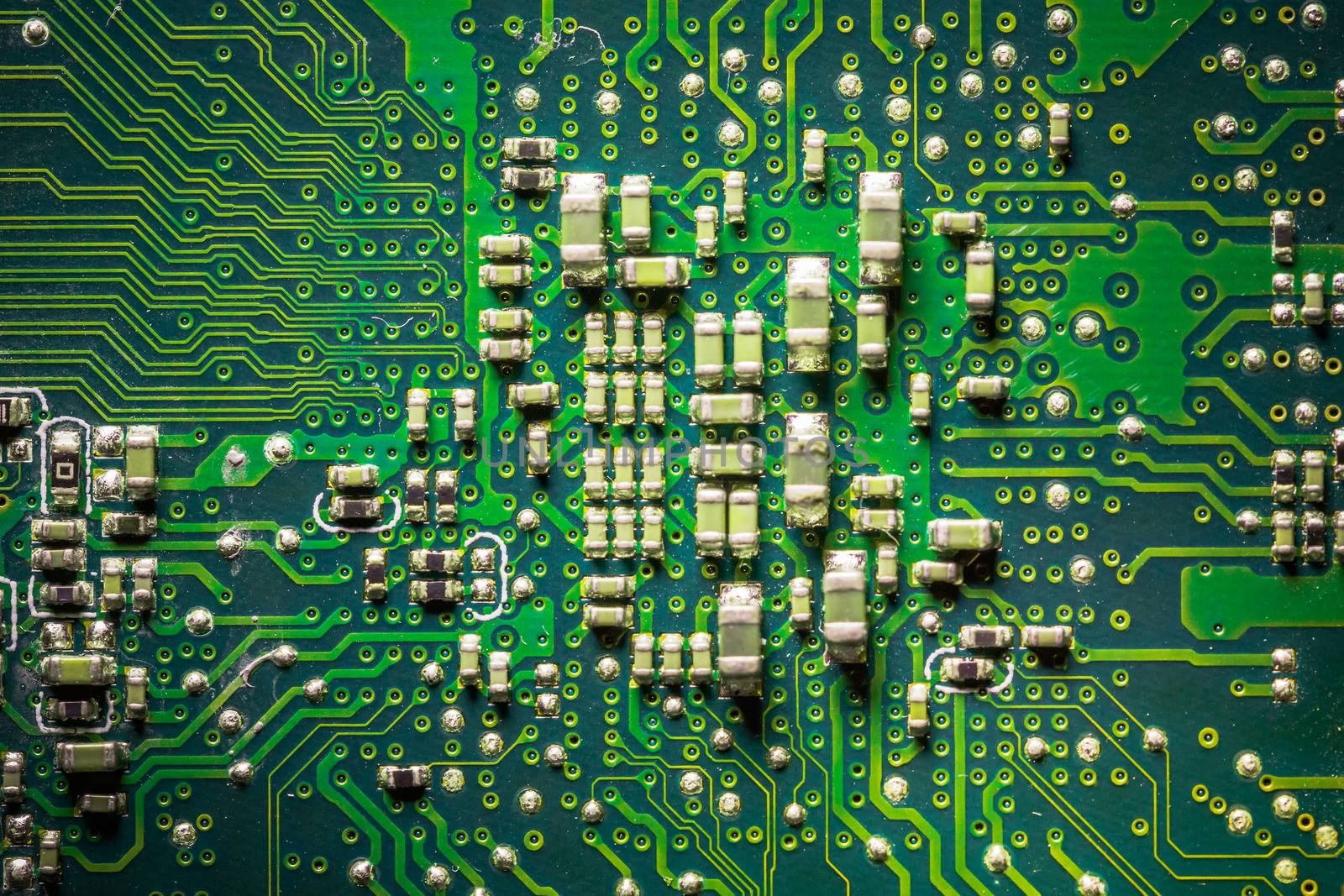 Close-up board with micro chips from an electrical appliance or computer. Concept of modern technology. Concept of electronics and microchips. SMD capacitors and resistors on green PCB. by petrsvoboda91