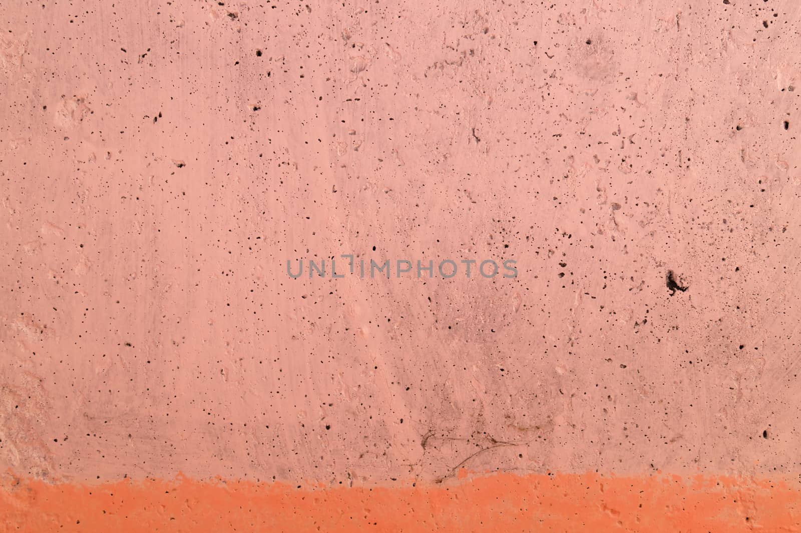 The pink concrete wall. The wall is textured.