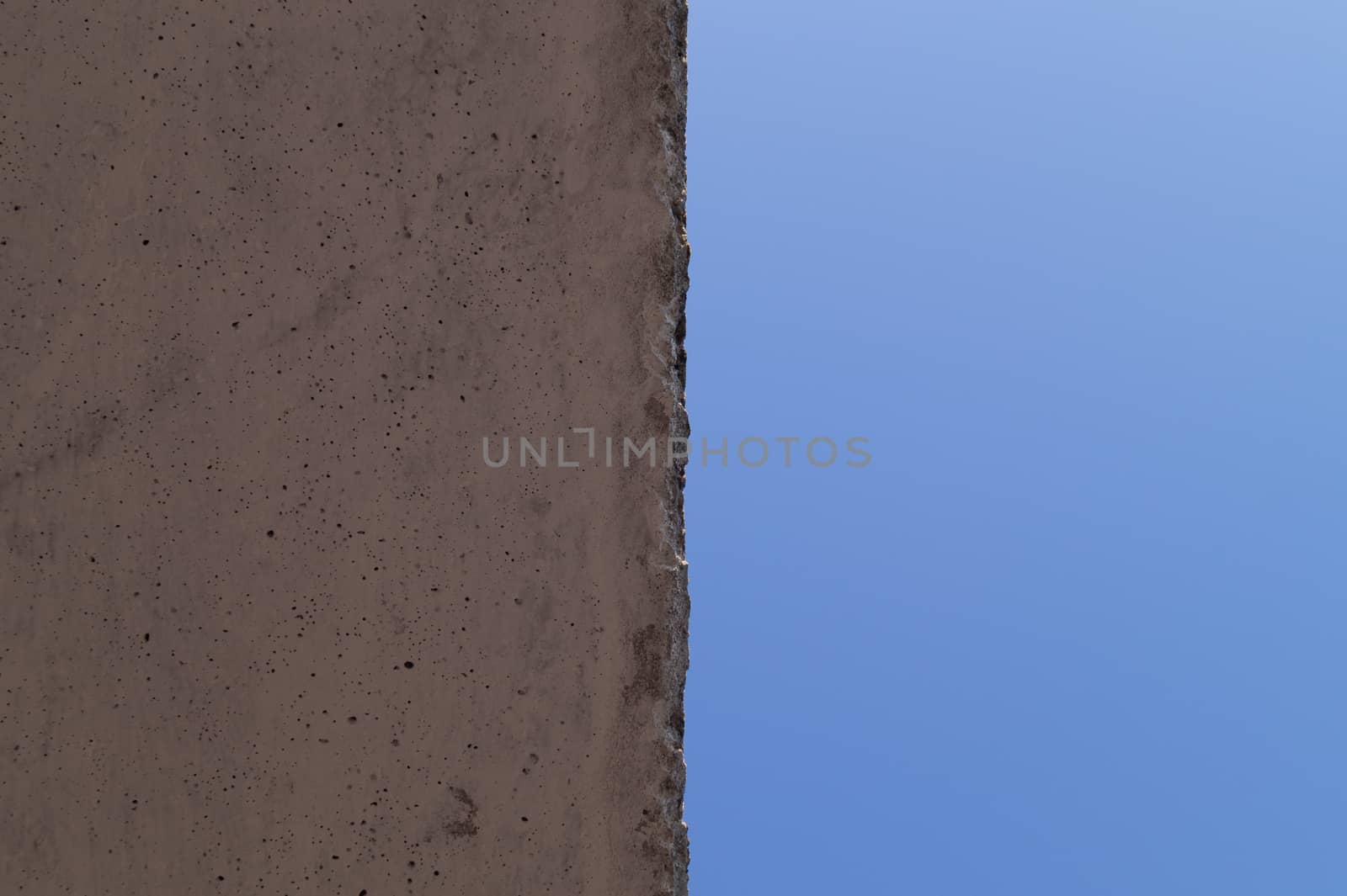 The wall and blue sky crossed the line in center. Abstract photo.