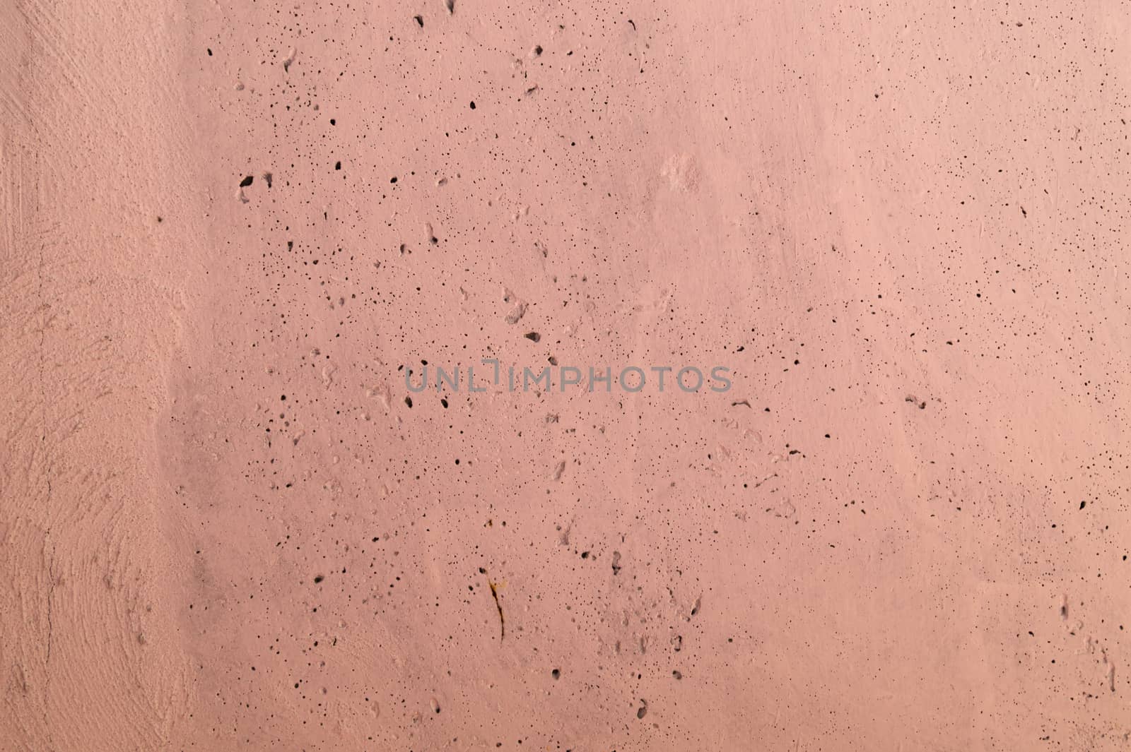 The pink concrete wall. The wall is textured.
