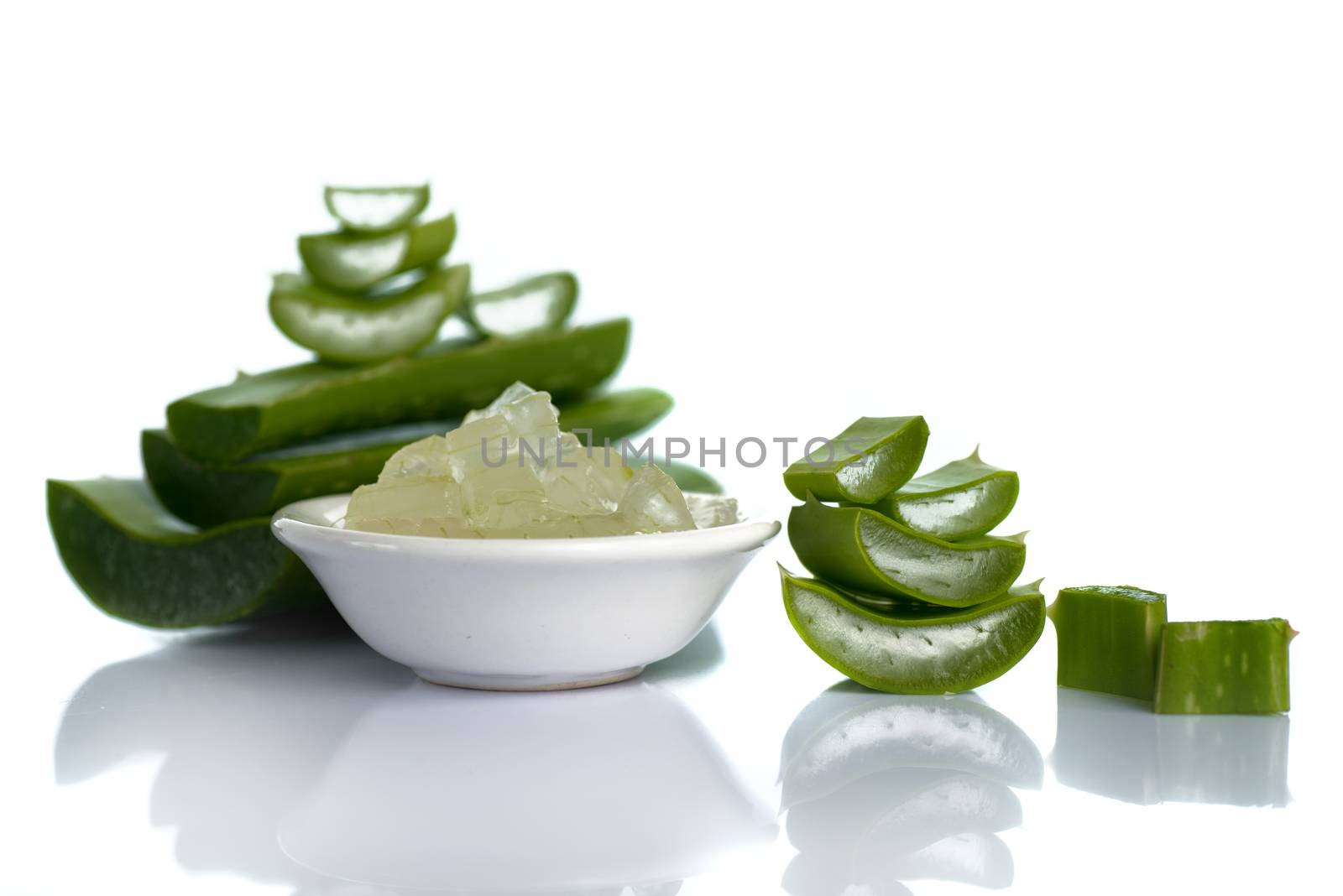 Slices of Aloe Vera leave and Aloe Vera gel in a bowl on a white background. Aloe Vera is a very useful herbal medicine for skin care and hair care.