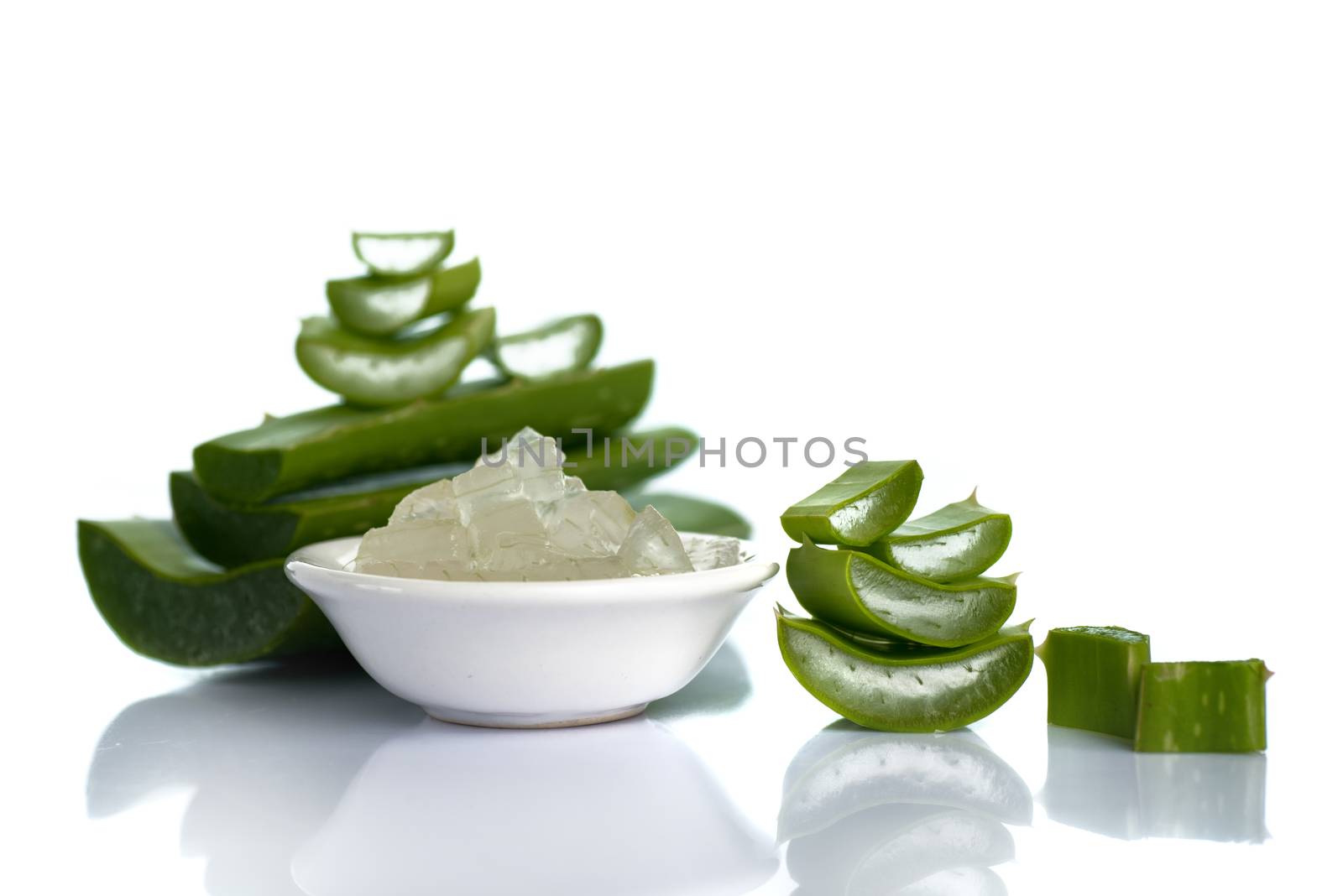 Slices of Aloe Vera leave and Aloe Vera gel in a bowl on a white background. Aloe Vera is a very useful herbal medicine for skin care and hair care.