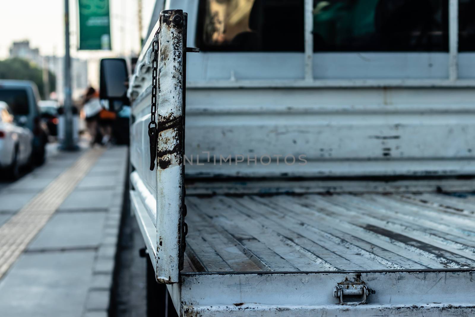 a closeup detail shoot to a white van - blurry cityscape as background. photo has taken at izmir/turkey.