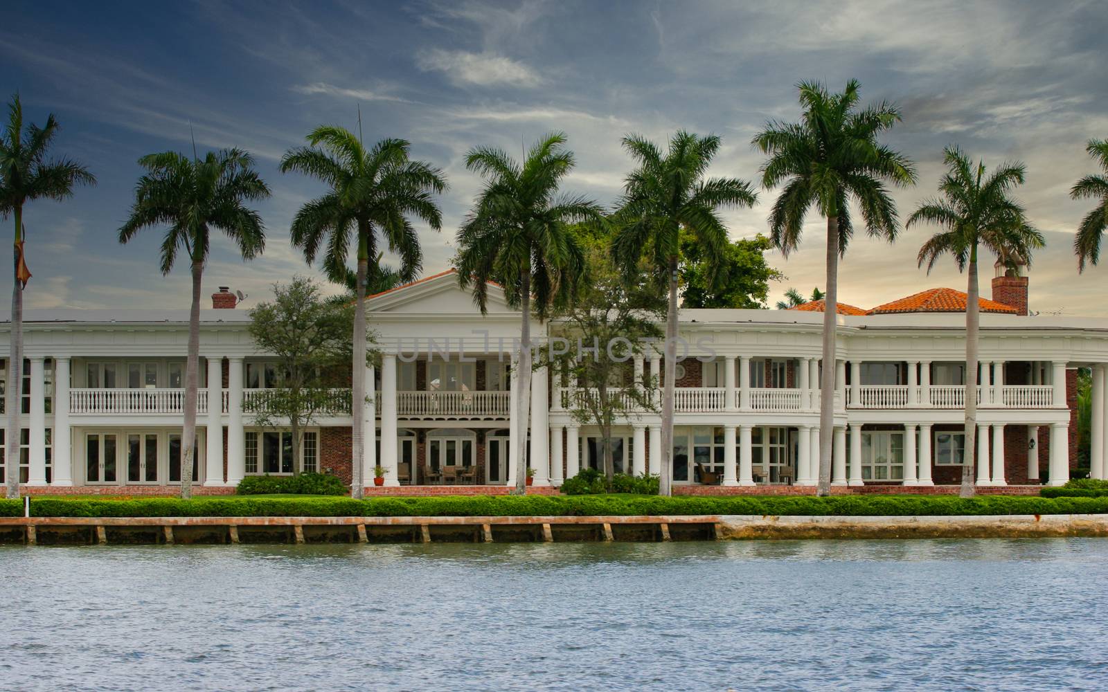 A coastal mansion lined with palm trees