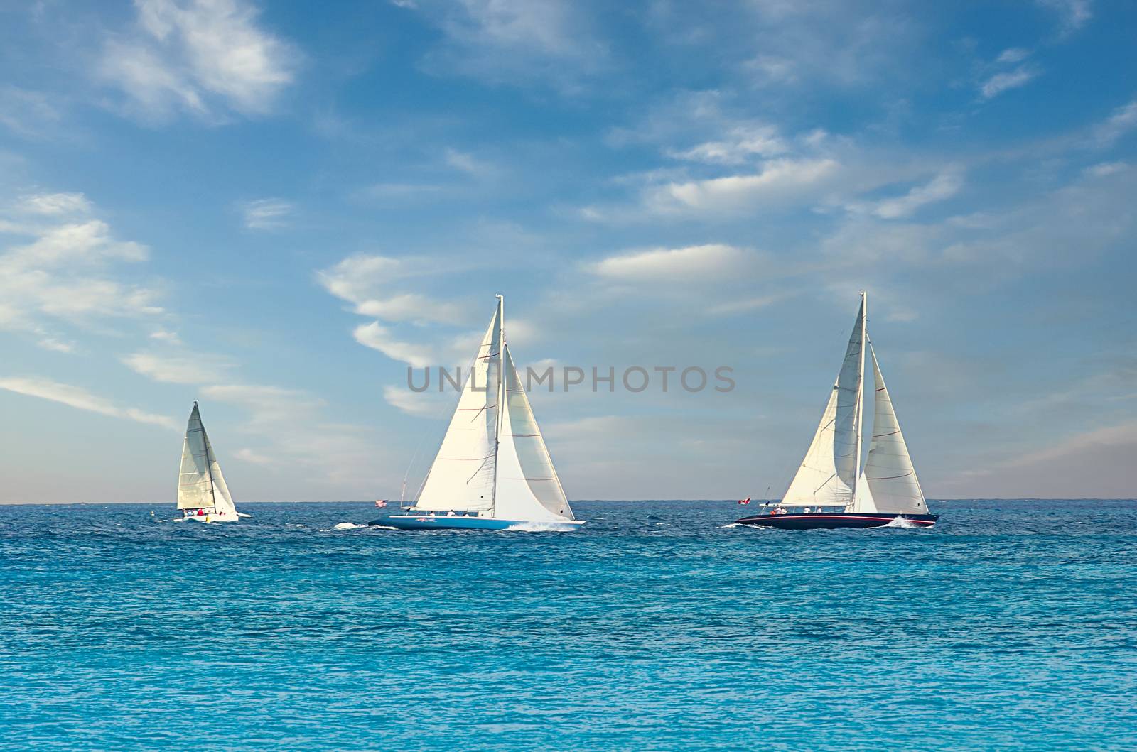 Three sailboats on the horizon in the ocean