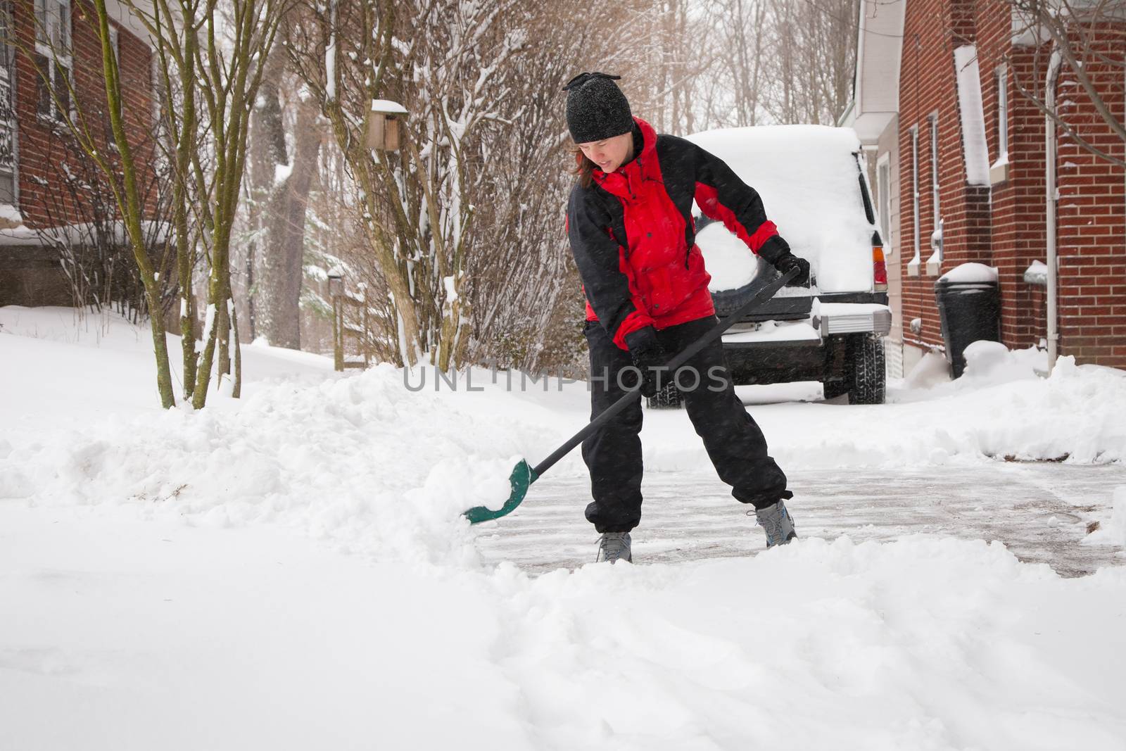 Woman Shoveling Winter Snow by patrickstock