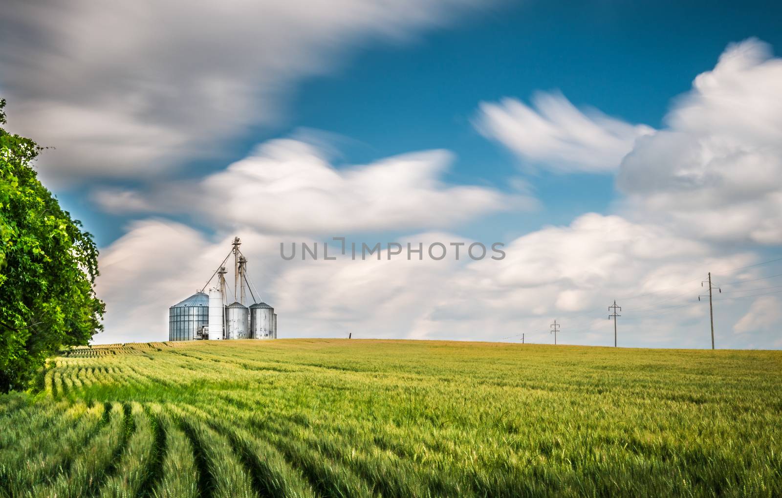 Grain Elevator on Hill with Blurry Clouds.