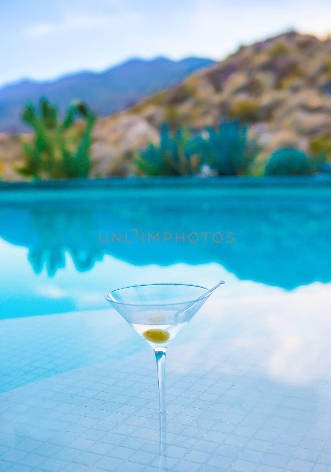 Martini on Pool Bar With Mountains in Background by patrickstock