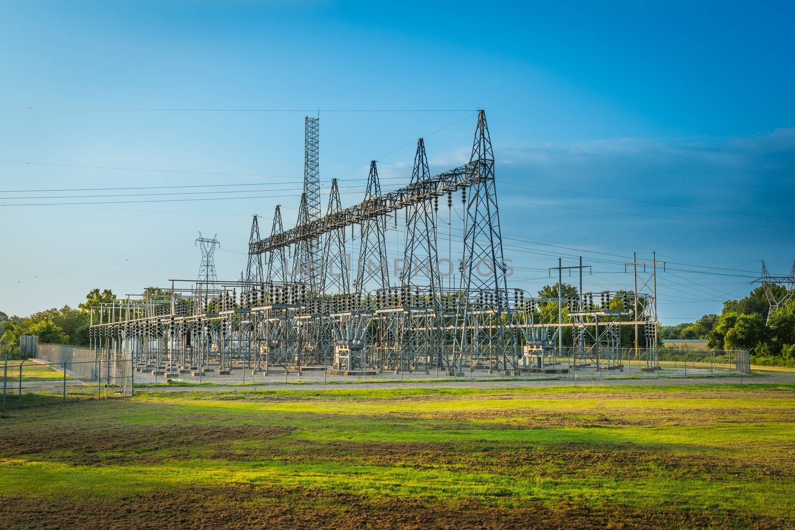 Electric substation at sunset with blue sky. by patrickstock