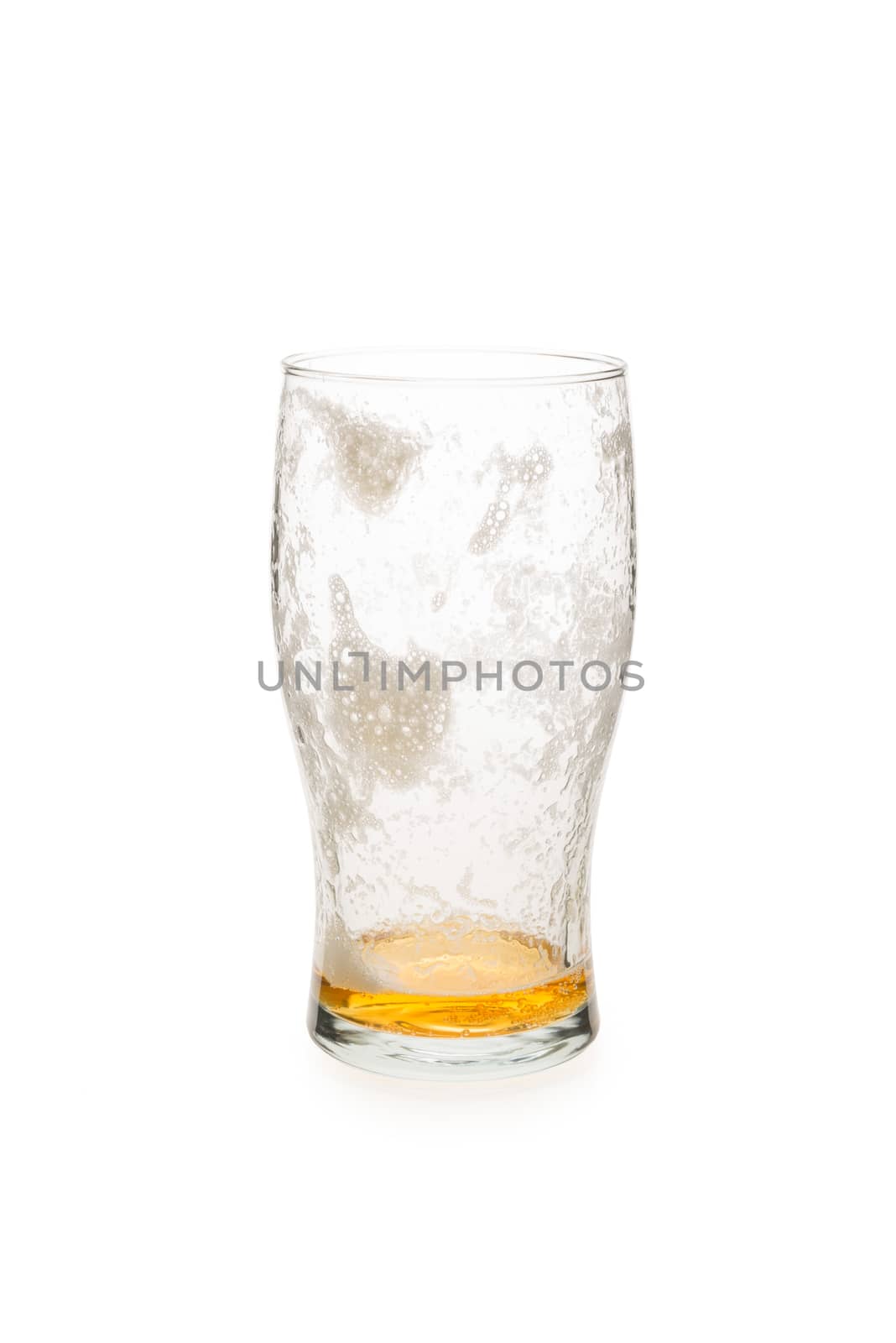Pint glass with just a little beer in the bottom of the galss.
